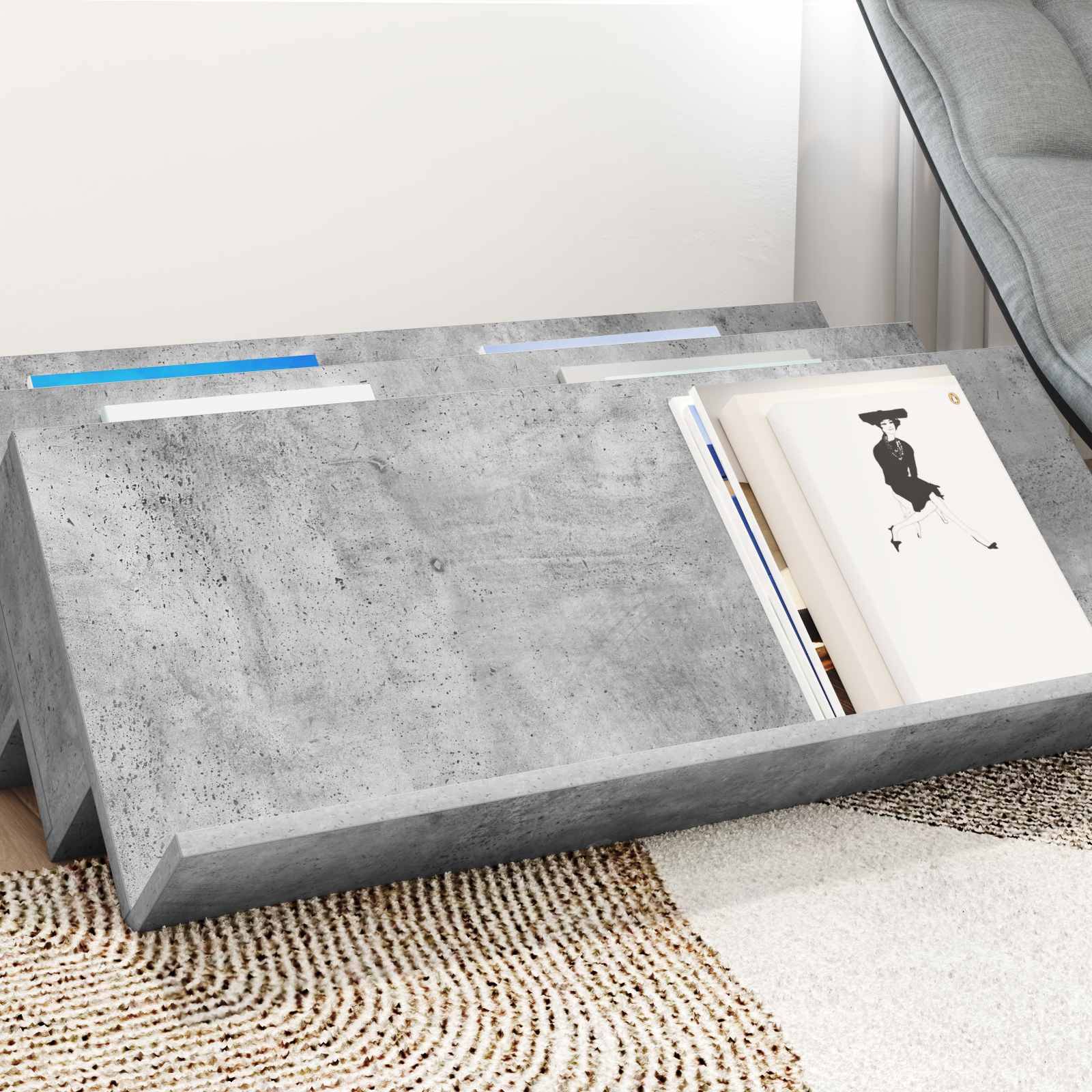 Moderner Betontisch mit elegantem Design, der eine Nut für Bücher und Zeitschriften aufweist und auf einem gemusterten Teppich in einem Wohnzimmer steht.
