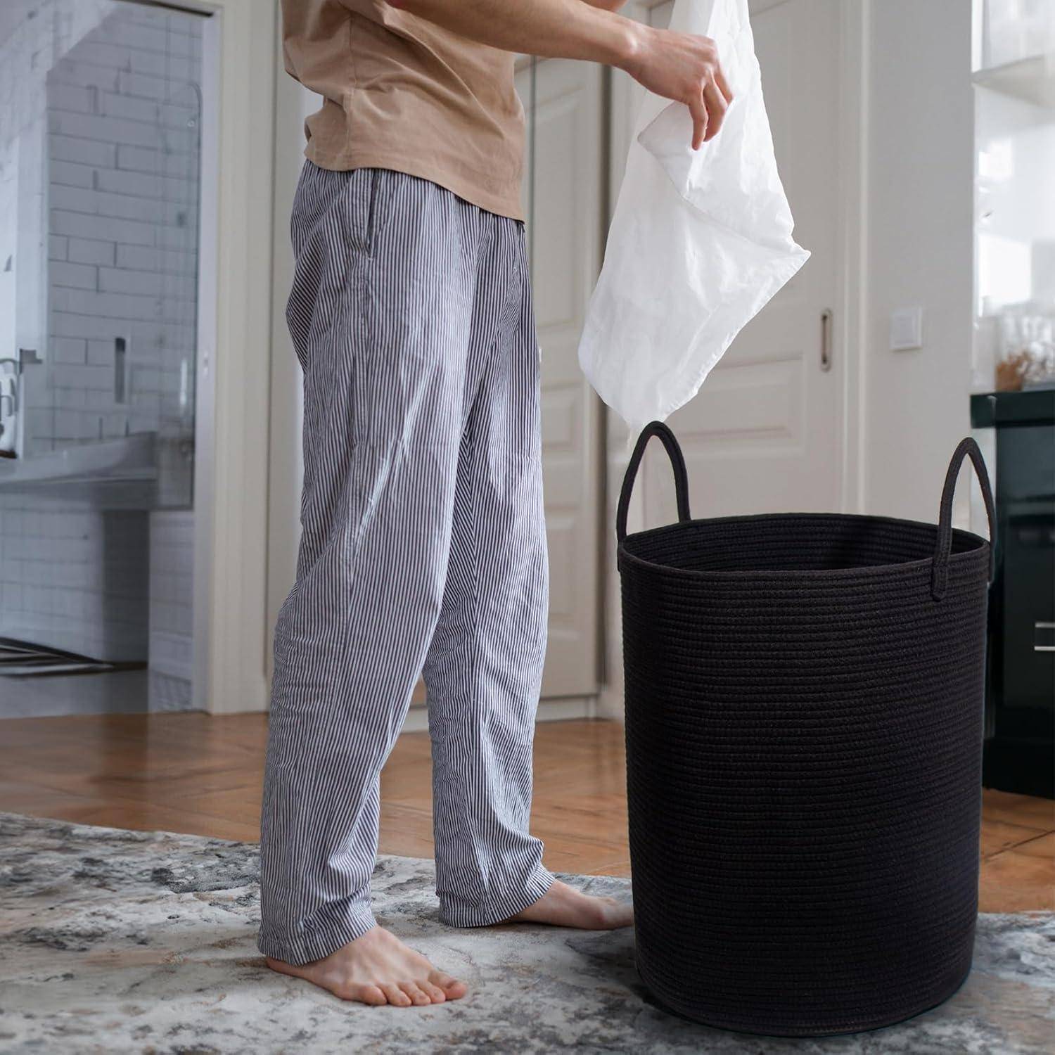 Mann in Pyjamas, der Papier in einen schwarzen Korb entsorgt und in einem modernen Raum mit Holzböden und hellen Wänden steht.