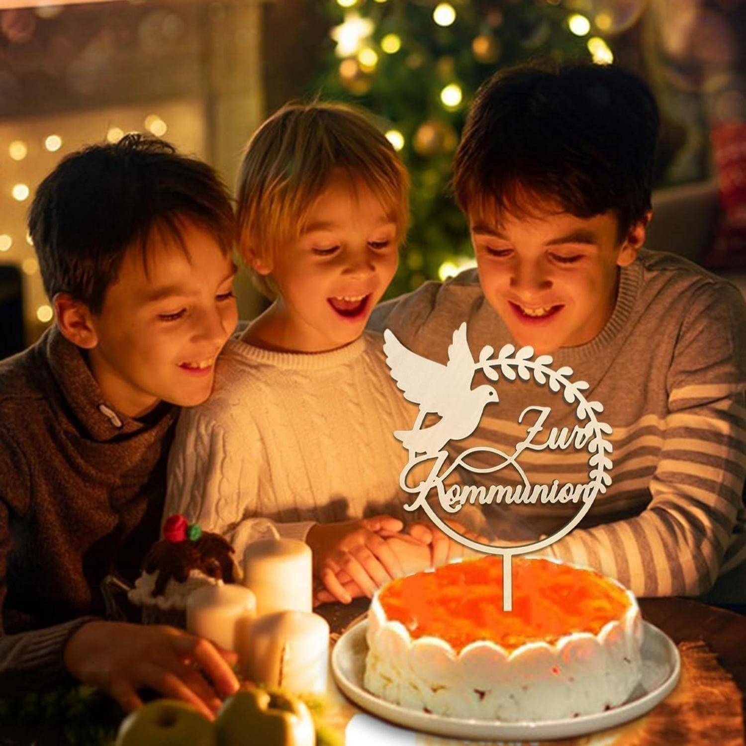Drei Kinder betrachten fröhlich einen Kuchen mit einem Tortendekoration mit der Aufschrift 'Zur Kommunion', umgeben von Kerzen und festlichen Dekorationen.
