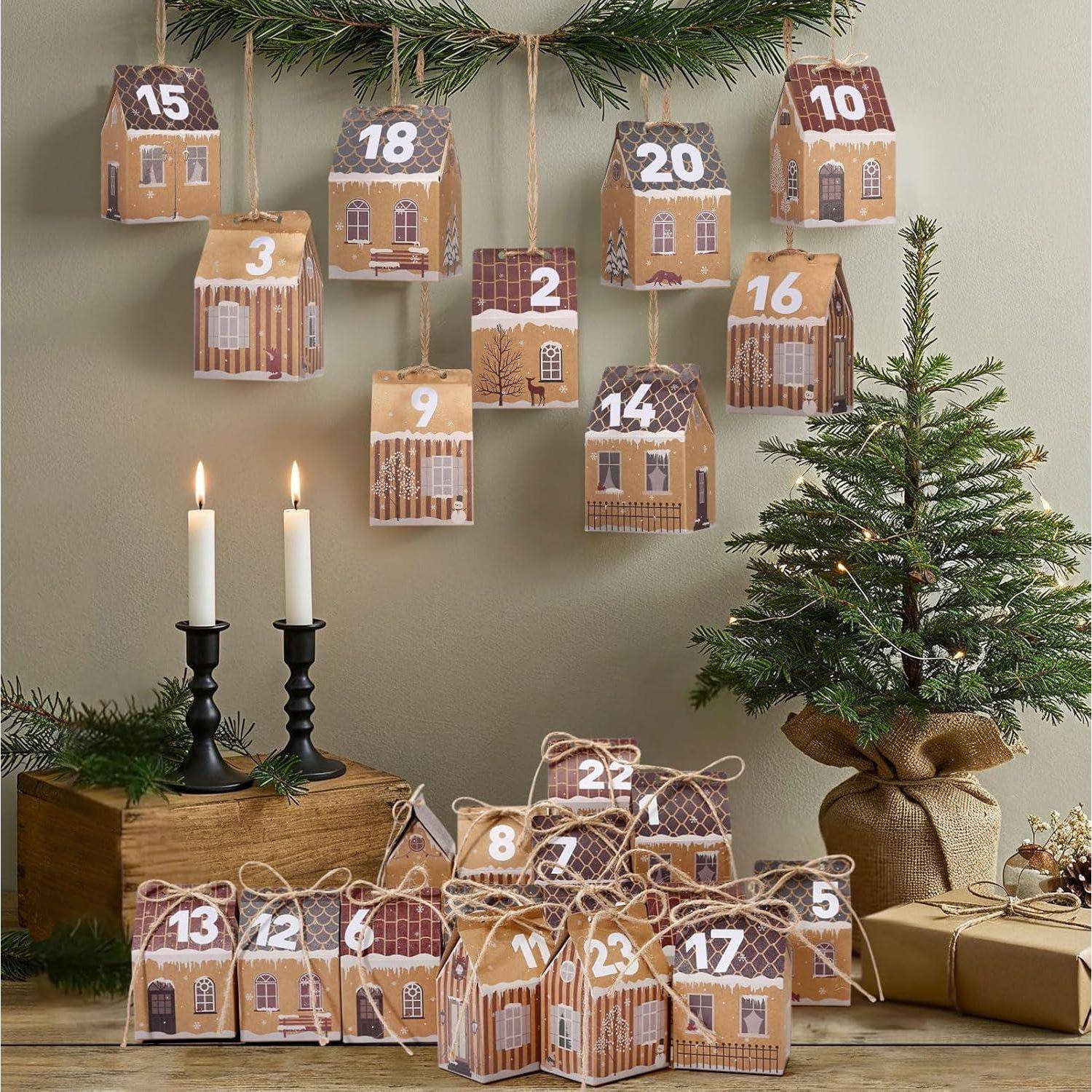 Adventskalender mit kleinen hausförmigen Schachteln, von 1 bis 24 nummeriert, angeordnet um Kerzen und einen kleinen Weihnachtsbaum, der den Dezember-Countdown anzeigt.