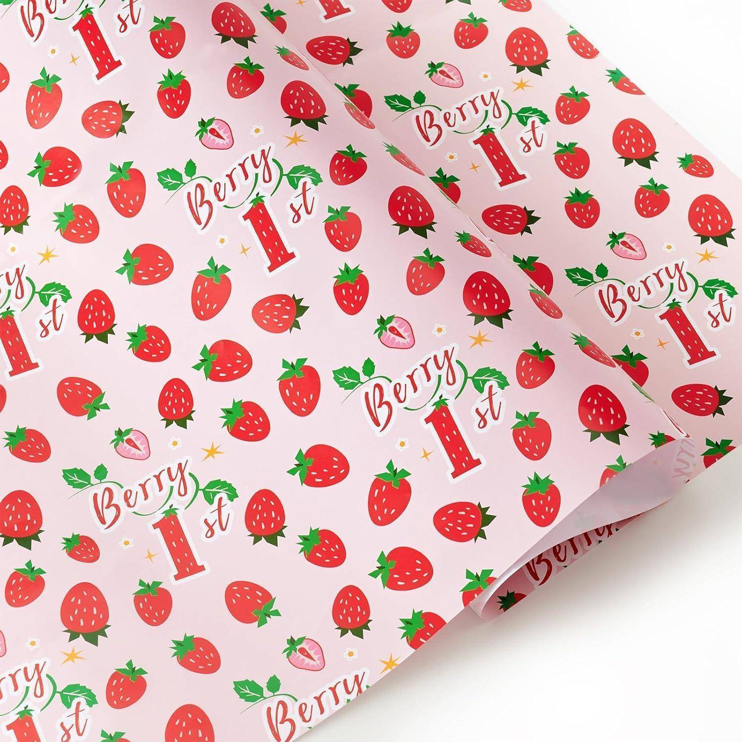 Geschenkpapier mit roten Erdbeeren und dem Text ‚Berry 1st' auf einem rosa Hintergrund.