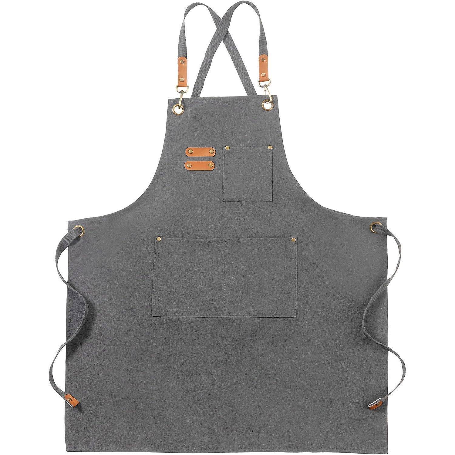 Eine graue Schürze mit braunen Lederriemen und Metalltüllen, ausgestattet mit einer Vordertasche und verstellbaren Halsgurten.