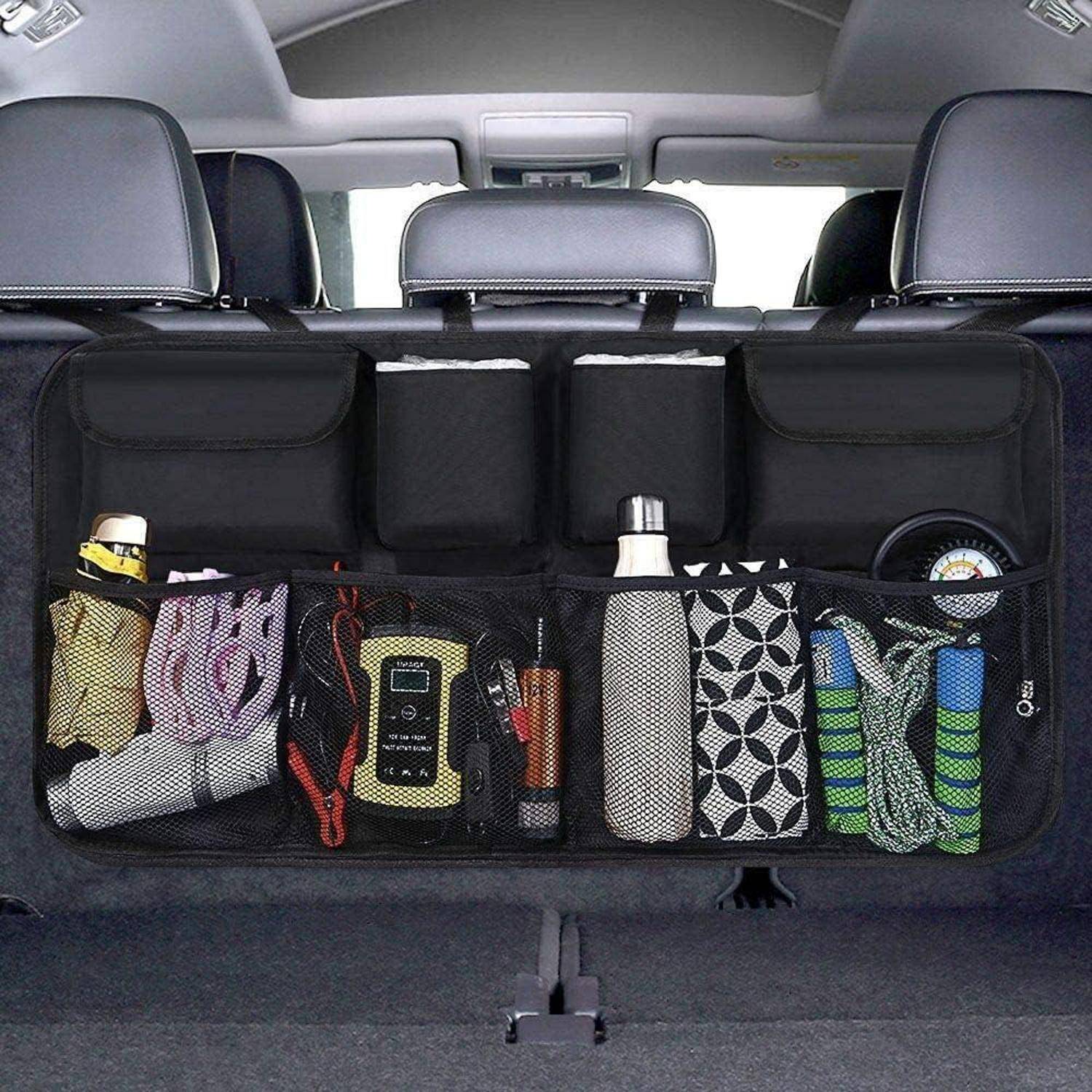 Kofferraum-Organizer mit Netztaschen, der Gegenstände wie eine Wasserflasche, ein Handtuch, Starthilfekabel, ein Werkzeug und zwei Aufbewahrungswürfel hält.