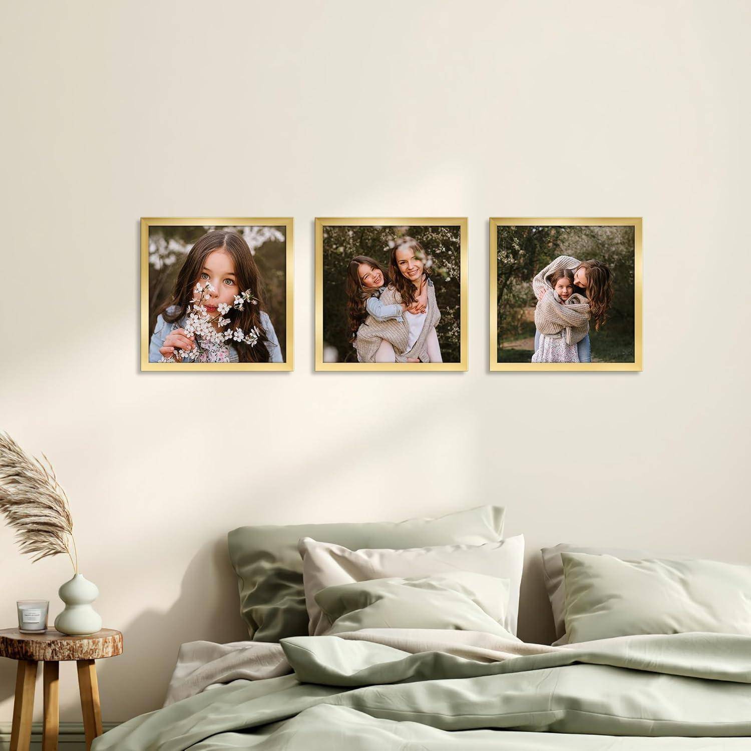 Eine Schlafzimmerwand mit drei gerahmten Fotos von lächelnden Mädchen, die Blumen halten. Darunter ein ordentlich gemachtes Bett mit grünen Kissen und einer Vase auf einem Beistelltisch.