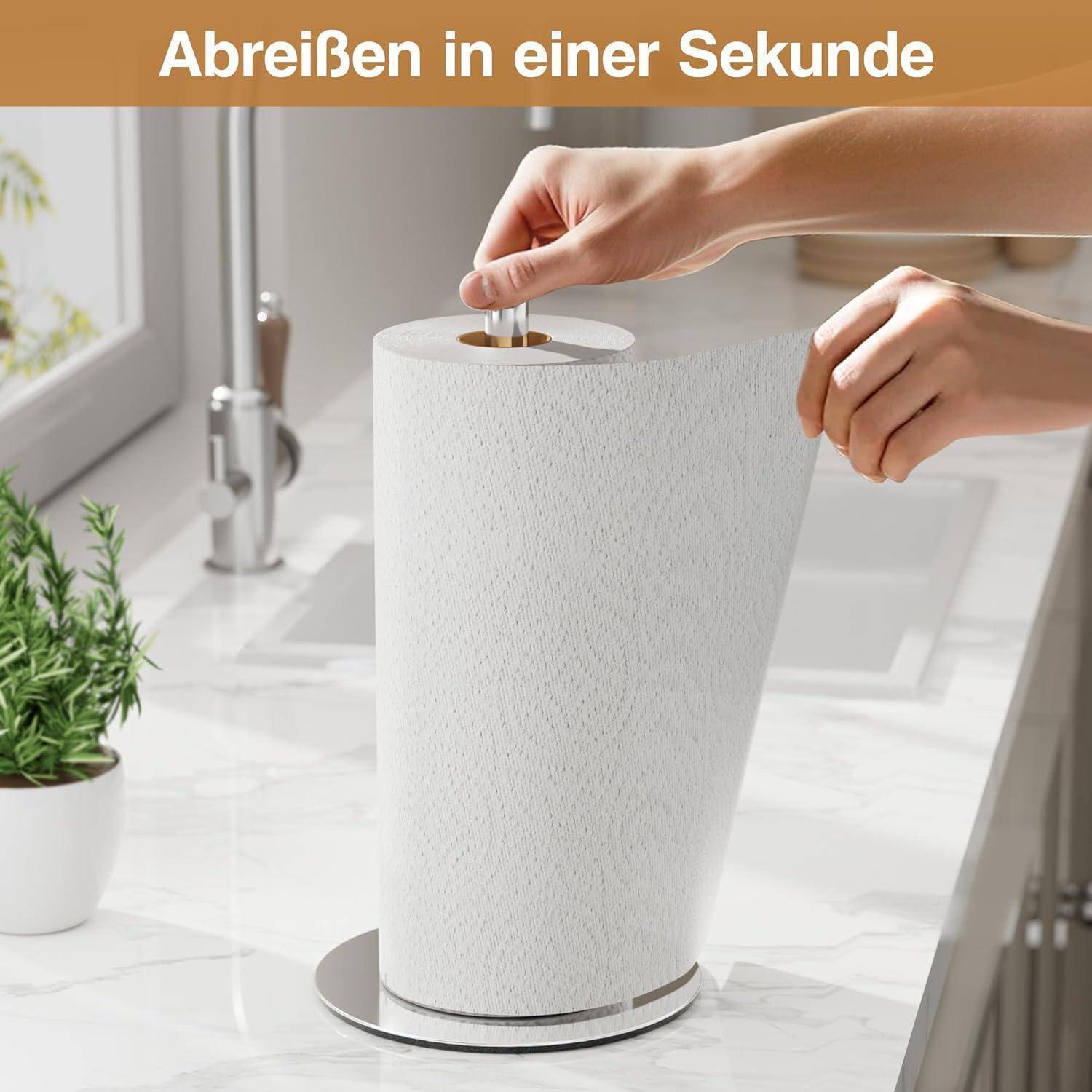 Eine Hand reißt ein Blatt von einer hohen Küchenpapierrolle auf einer Küchenarbeitsplatte ab, mit einer kleinen Pflanze in der Nähe. Deutscher Text oben liest sich: 'Abreißen in einer Sekunde'.