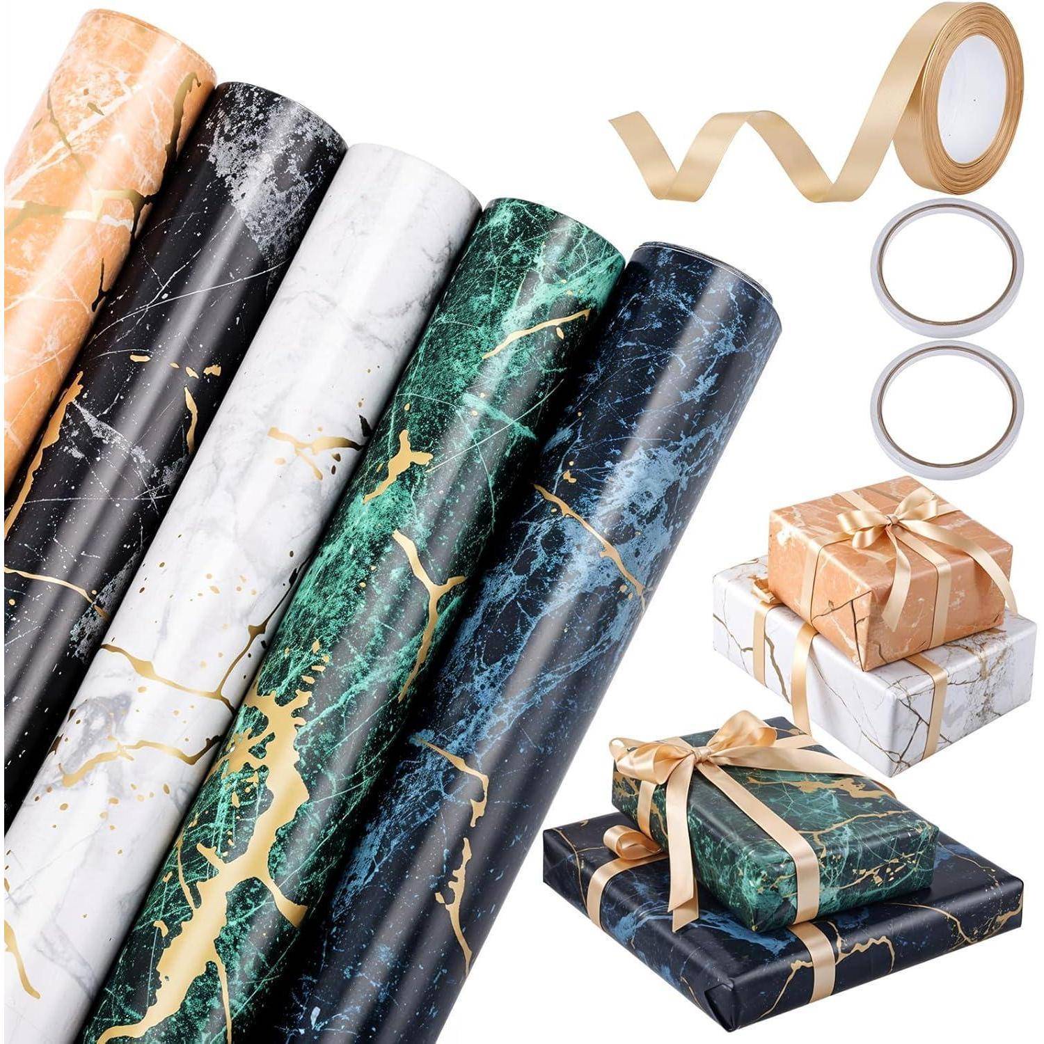 Verschiedene Rollen von marmoriertem Geschenkpapier in unterschiedlichen Farben sind neben Bändern, Klebeband und eingepackten Geschenkkartons zu sehen.