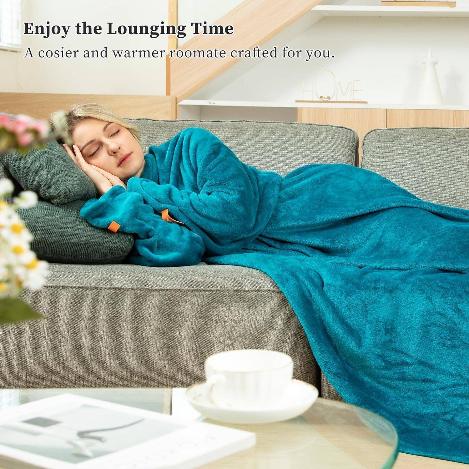 Eine Person ruht auf einem Sofa, in eine türkisfarbene Decke gehüllt, und vermittelt Entspannung und Behaglichkeit.