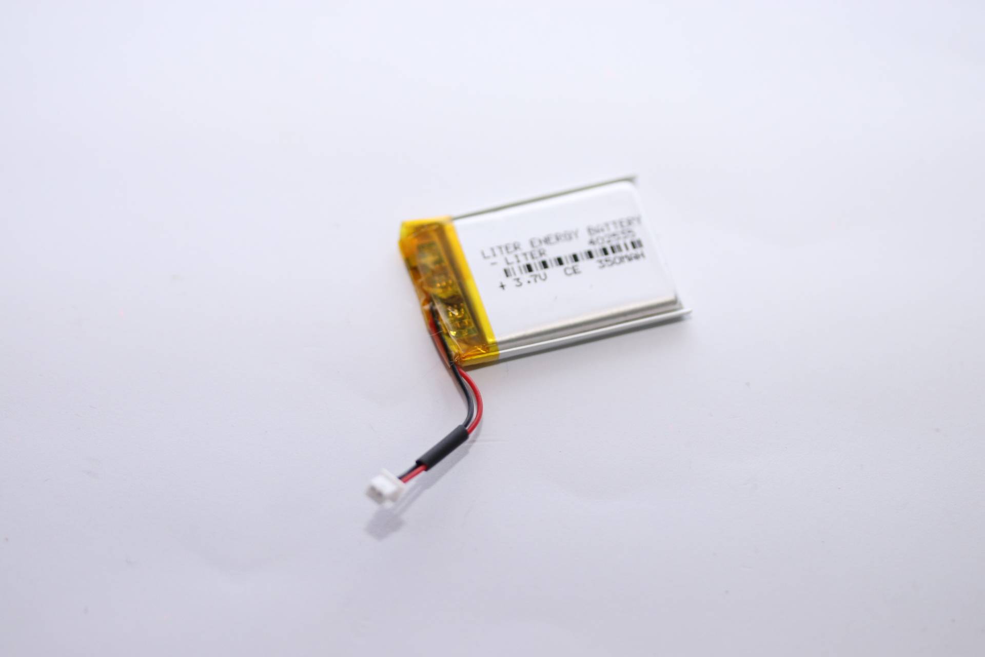 Eine kleine rechteckige Lithiumbatterie mit Kabeln ist angeschlossen und auf einem weißen Hintergrund platziert.