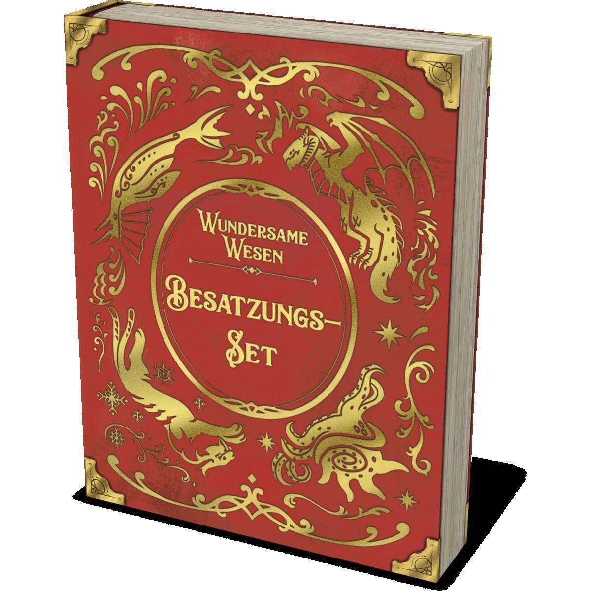 Ein rotes Buch mit dem Titel ‚Wundersame Wesen Besatzungs-Set', das auf dem Einband mit kunstvollen Golddrachen-Designs verziert ist.