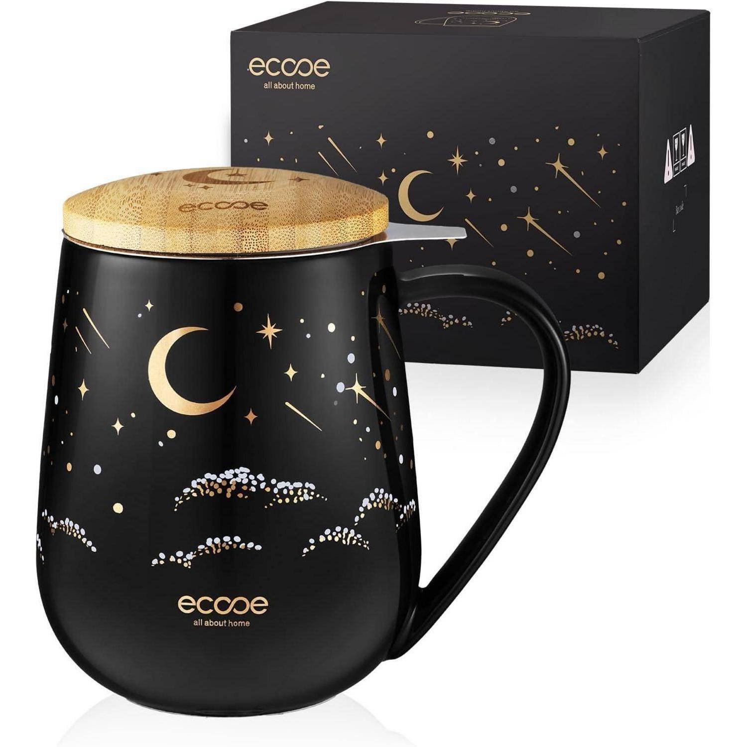 Eine schwarze Tasse mit goldenen kosmischen Designs, einschließlich einer Mondsichel und Sternen, mit der Markenbezeichnung 