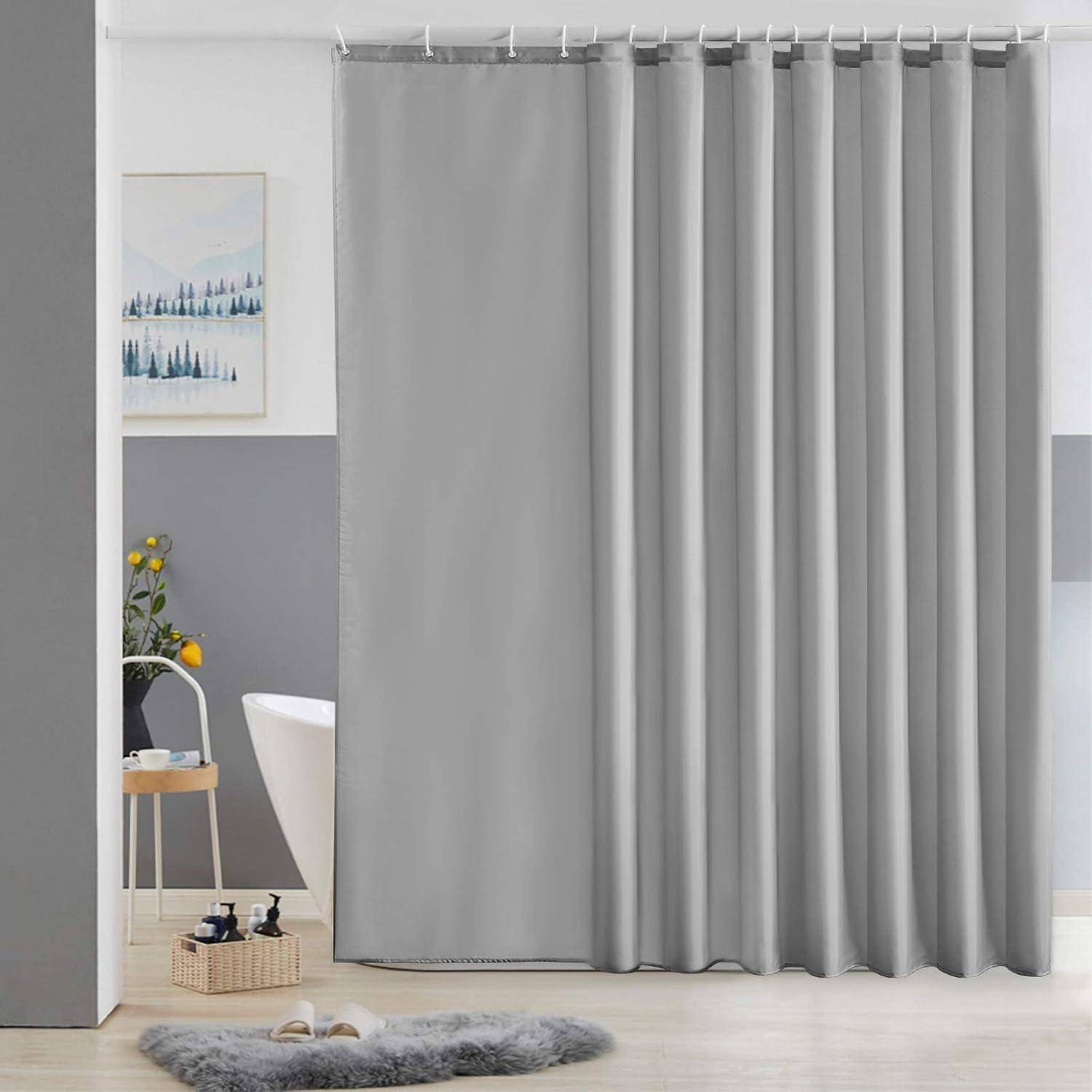 Ein graues Duschvorhang hängt in einem modernen Badezimmer mit einer gepolsterten Matte, einem kleinen Tisch mit Toilettenartikeln und einer Topfpflanze in der Nähe der Badewanne.