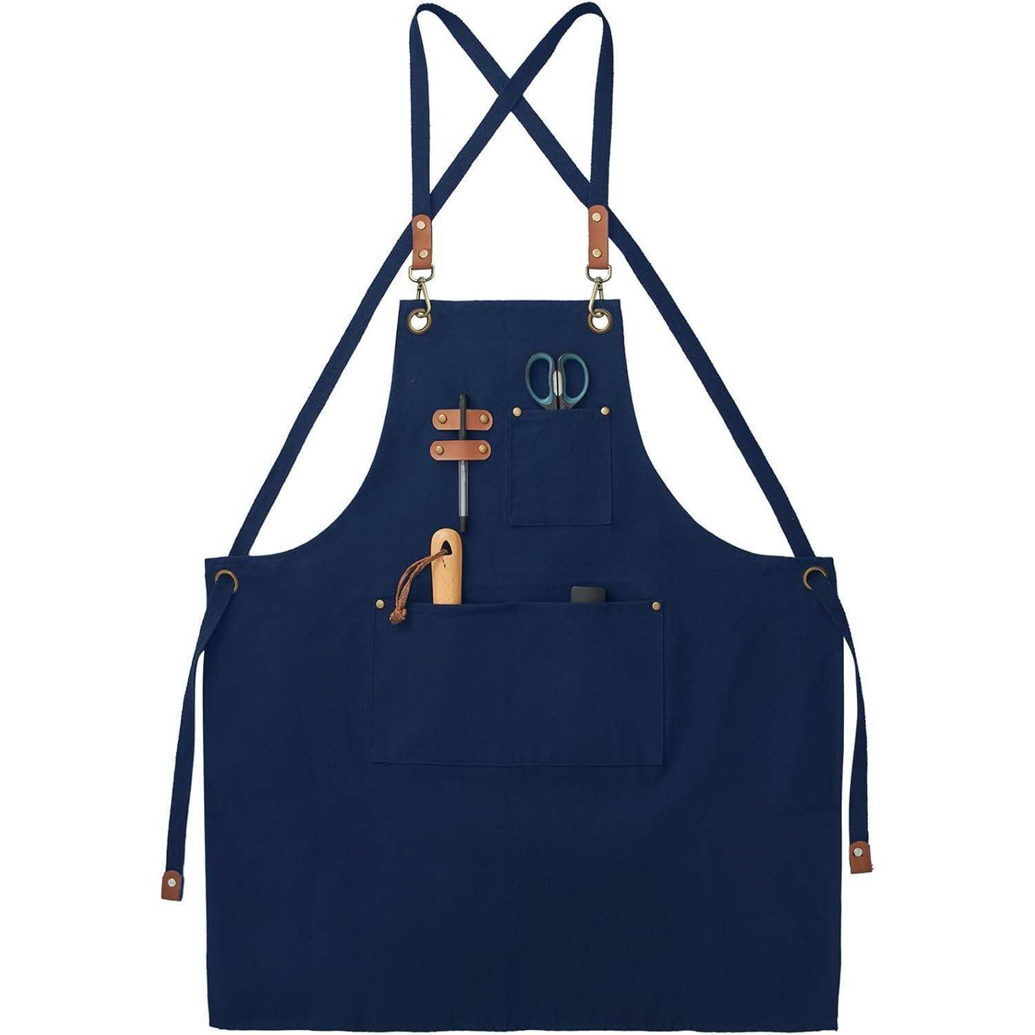 Eine blaue Schürze mit mehreren Taschen und Lederriemen. Sie hält eine Schere und ein kleines Werkzeug, was auf eine Verwendung für Handarbeiten oder Kochen hindeutet.