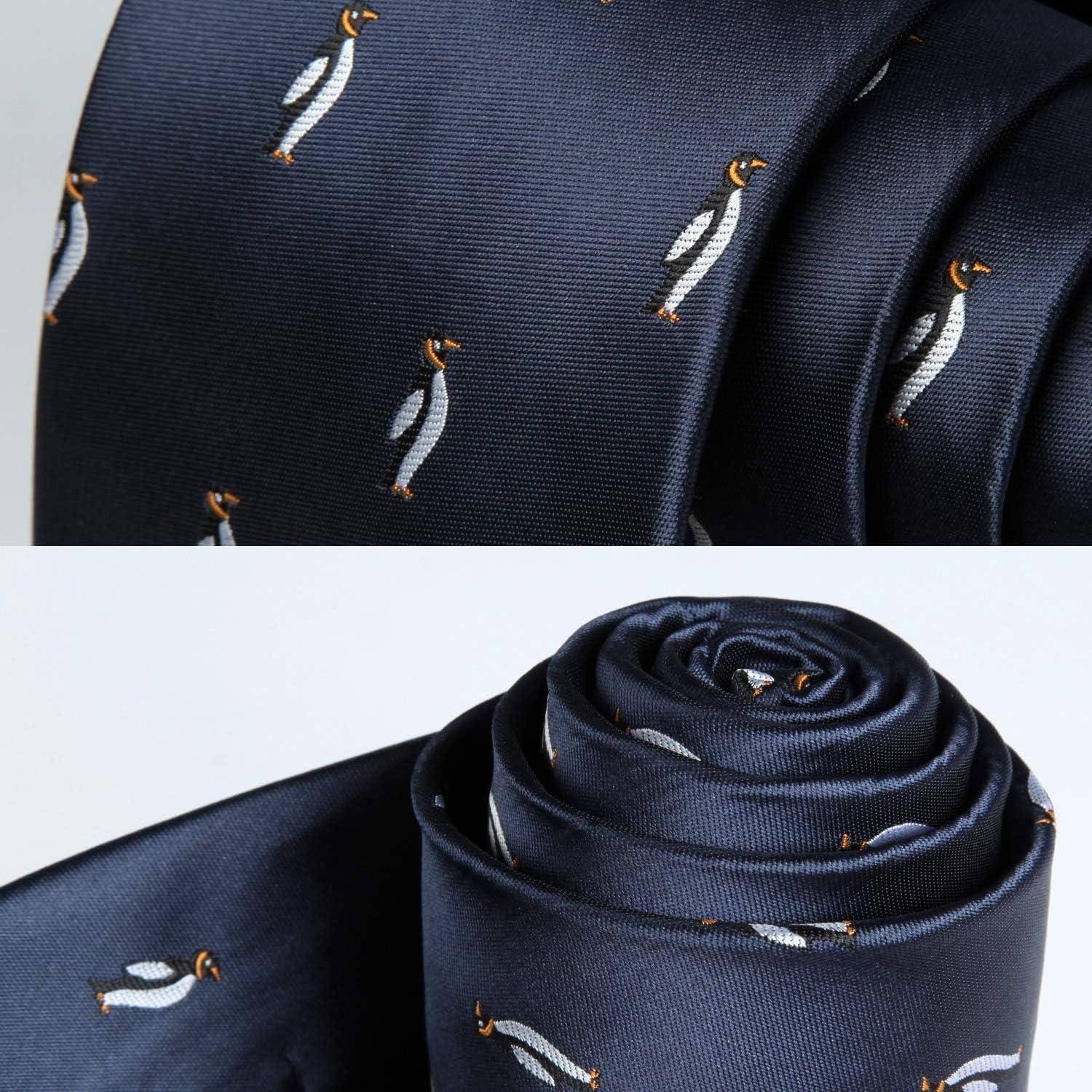 Eine marineblaue Seidenkrawatte mit kleinen bestickten Pinguin-Motiven ist zu sehen, in der unteren Hälfte teilweise aufgerollt und in der oberen Hälfte ausgerollt.