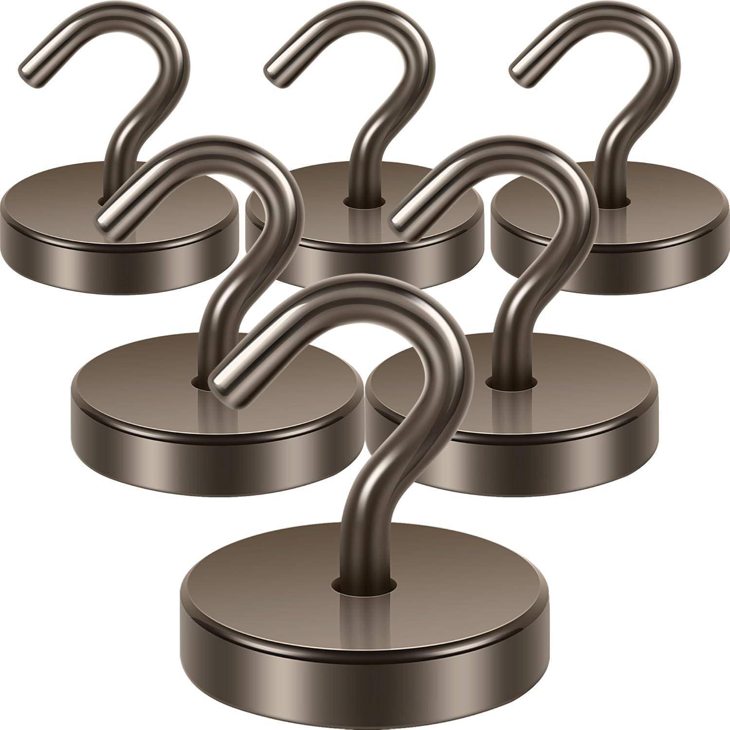 Fünf metallische Haken mit kreisförmigen Basen sind in einer versetzten Formation angeordnet. Die Haken sind S-förmig und erscheinen poliert.