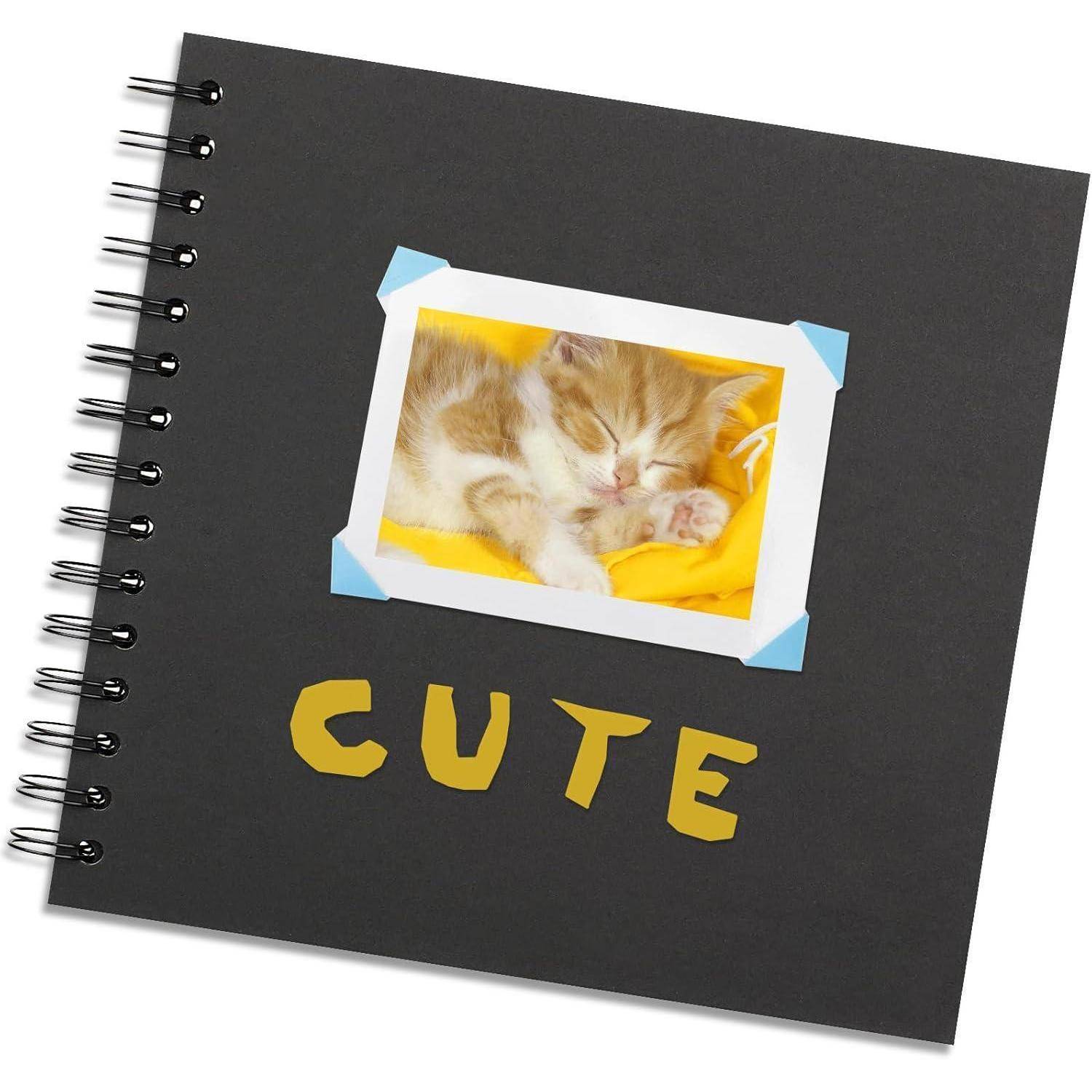 Eine Scrapbook-Titelseite zeigt ein Foto eines schlafenden Kätzchens, das mit gelben Buchstaben als ‚CUTE' beschriftet ist, auf einem schwarzen Hintergrund mit Spiralbindung.