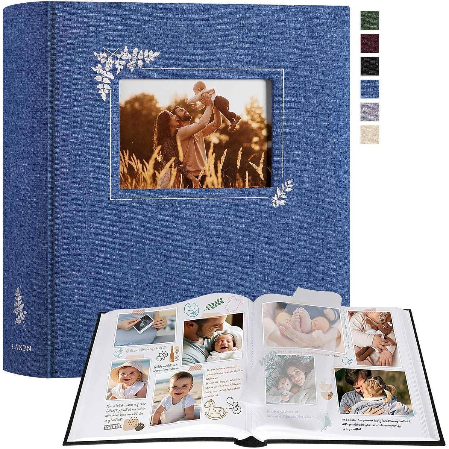 Ein blaues Fotoalbum mit geprägtem Blattmotiv, das eine geöffnete Seite mit Familienfotos und Erinnerungsstücken zeigt. Auf dem Titelfoto hebt eine Mutter ihr Baby.