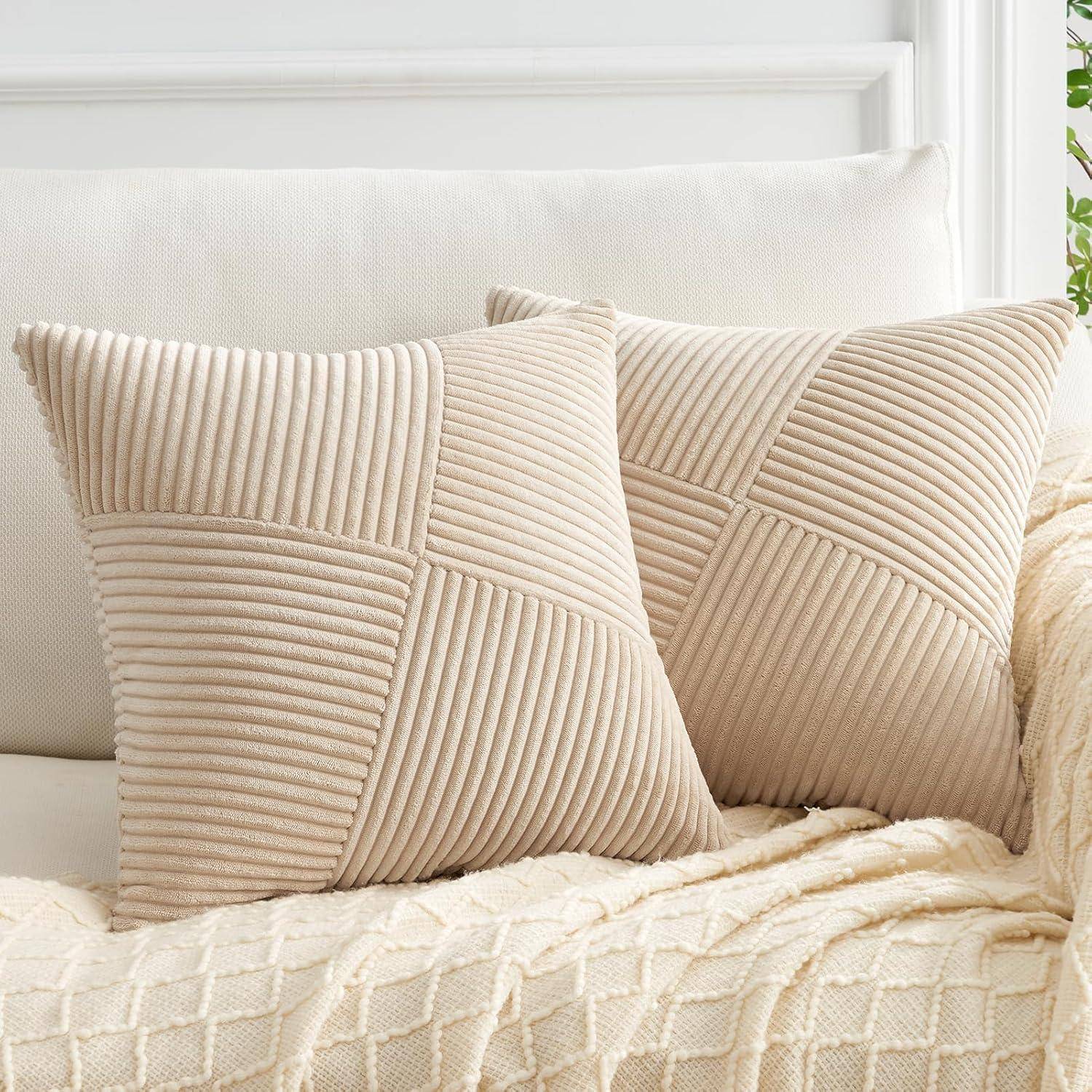 Zwei beige, gerippte Zierkissen auf einem cremefarbenen gesteppten Sofa in einem hellen, gemütlichen Wohnzimmer.