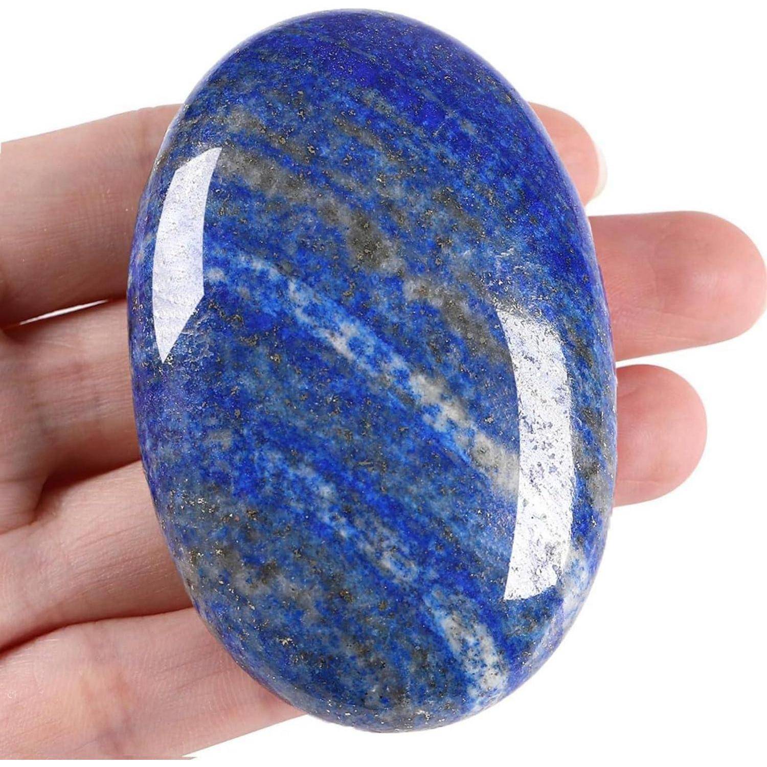 Eine Hand hält einen polierten, ovalen blauen Stein mit weißen und goldenen Sprenklern, der seine glatte Textur und lebendigen Farbvariationen präsentiert.