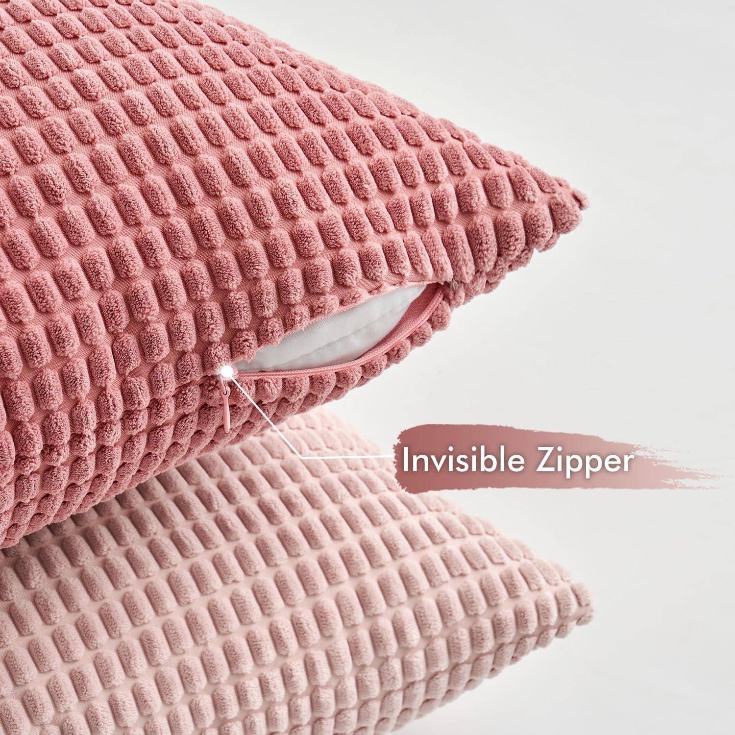 Zwei strukturierte rosa Kissen mit einer hervorgehobenen ‚Unsichtbaren Reißverschluss'-Funktion auf einem der Kissen.