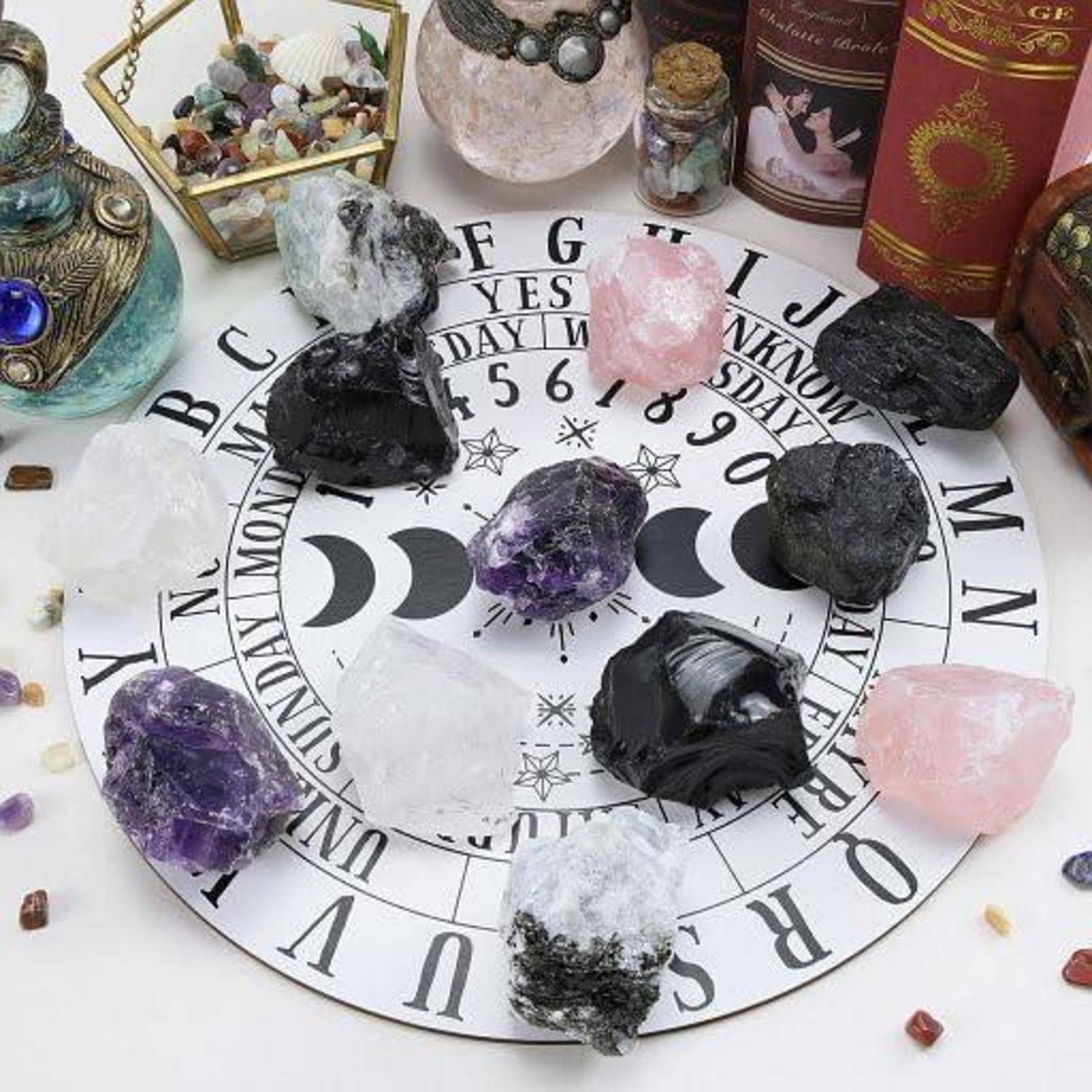 Eine kreisförmige Astrologie-Karte mit verschiedenen Kristallen, darunter Amethyst und Rosenquarz, die auf der Karte platziert sind. Tarotkarten und dekorative Gegenstände umgeben die Karte.