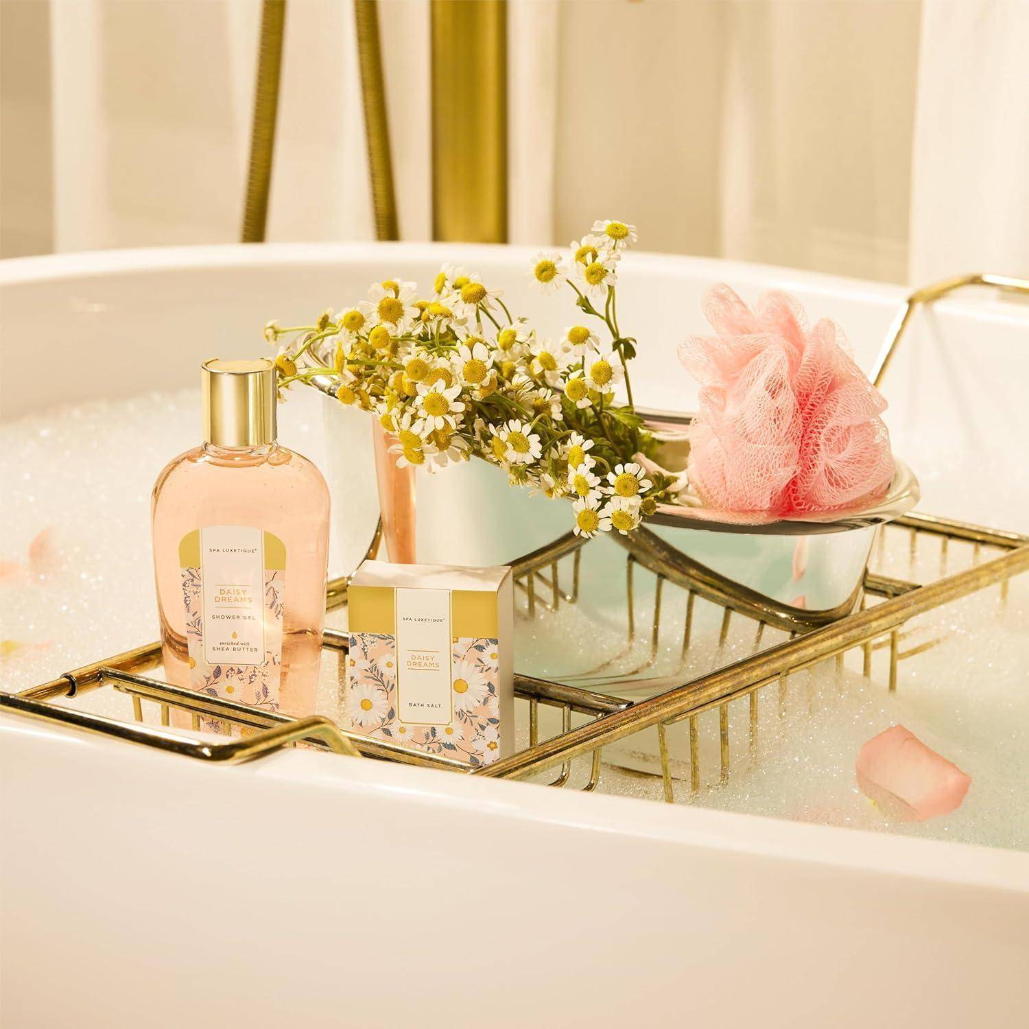 Eine Badewanne mit einem Tablett, das eine pinke Flasche, eine Schachtel, Blumen und einen Luffa enthält, umgeben von Blasen und Rosenblüten, die eine entspannende Atmosphäre schaffen.