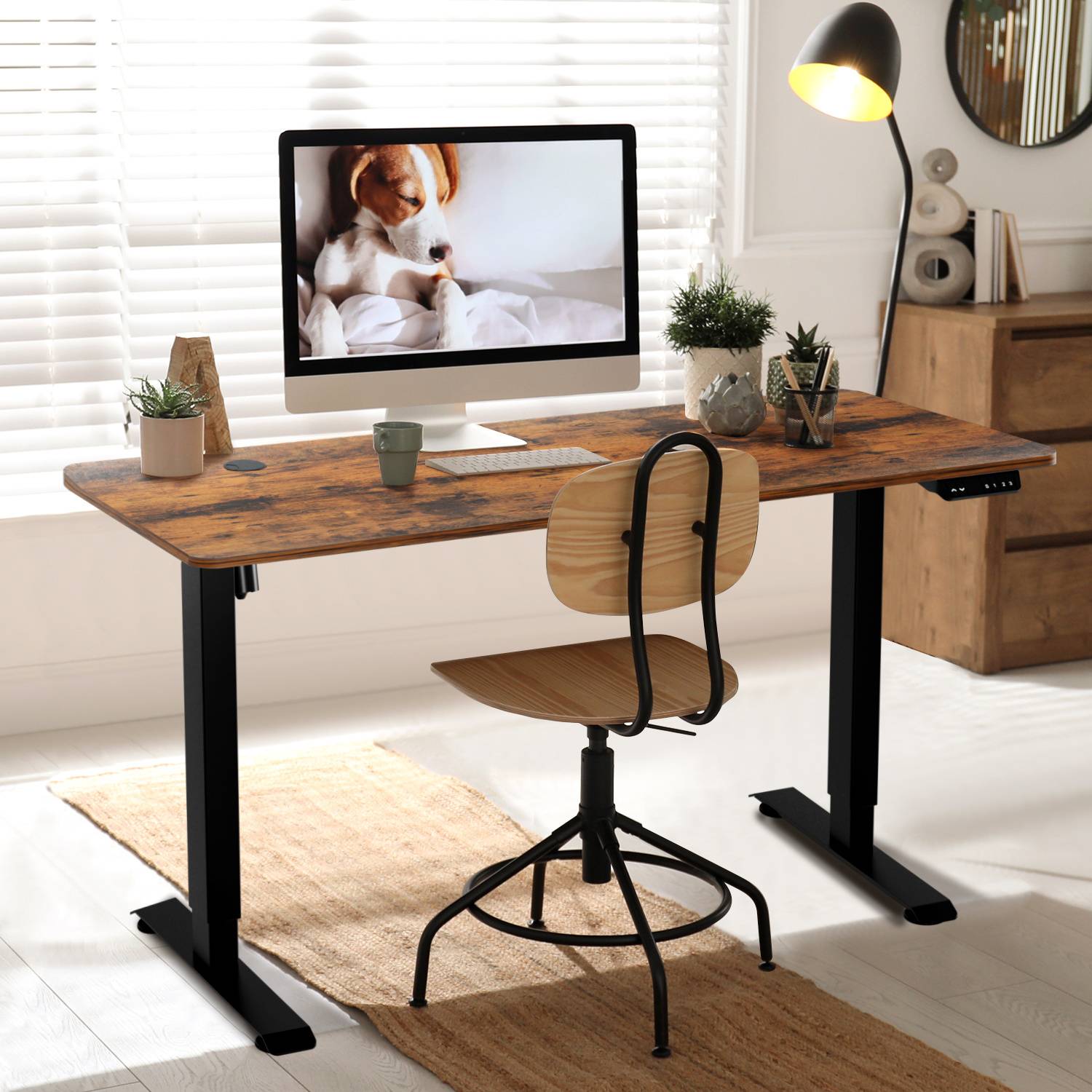 Ein Home Office mit einem Holzschreibtisch, einem verstellbaren Stuhl und einem Computer, auf dem ein Hundefoto angezeigt wird. Natürliches Licht von einem Fenster erhellt den Raum.