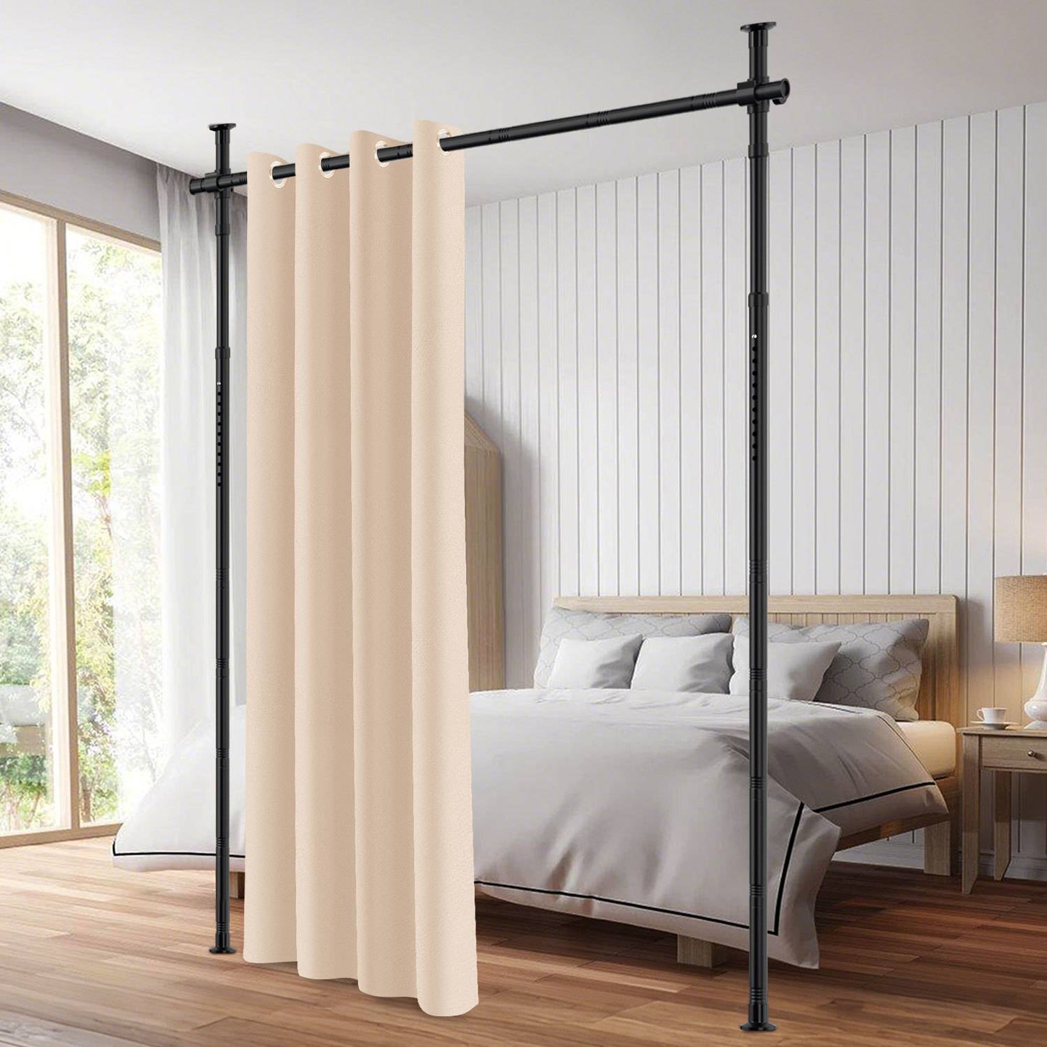 Ein modernes Schlafzimmer verfügt über einen beigen Vorhangraumteiler an einer schwarzen Stange, der den Raum teilt. Es gibt ein ordentlich gemachtes Bett mit weißer Bettwäsche und einen Nachttisch.