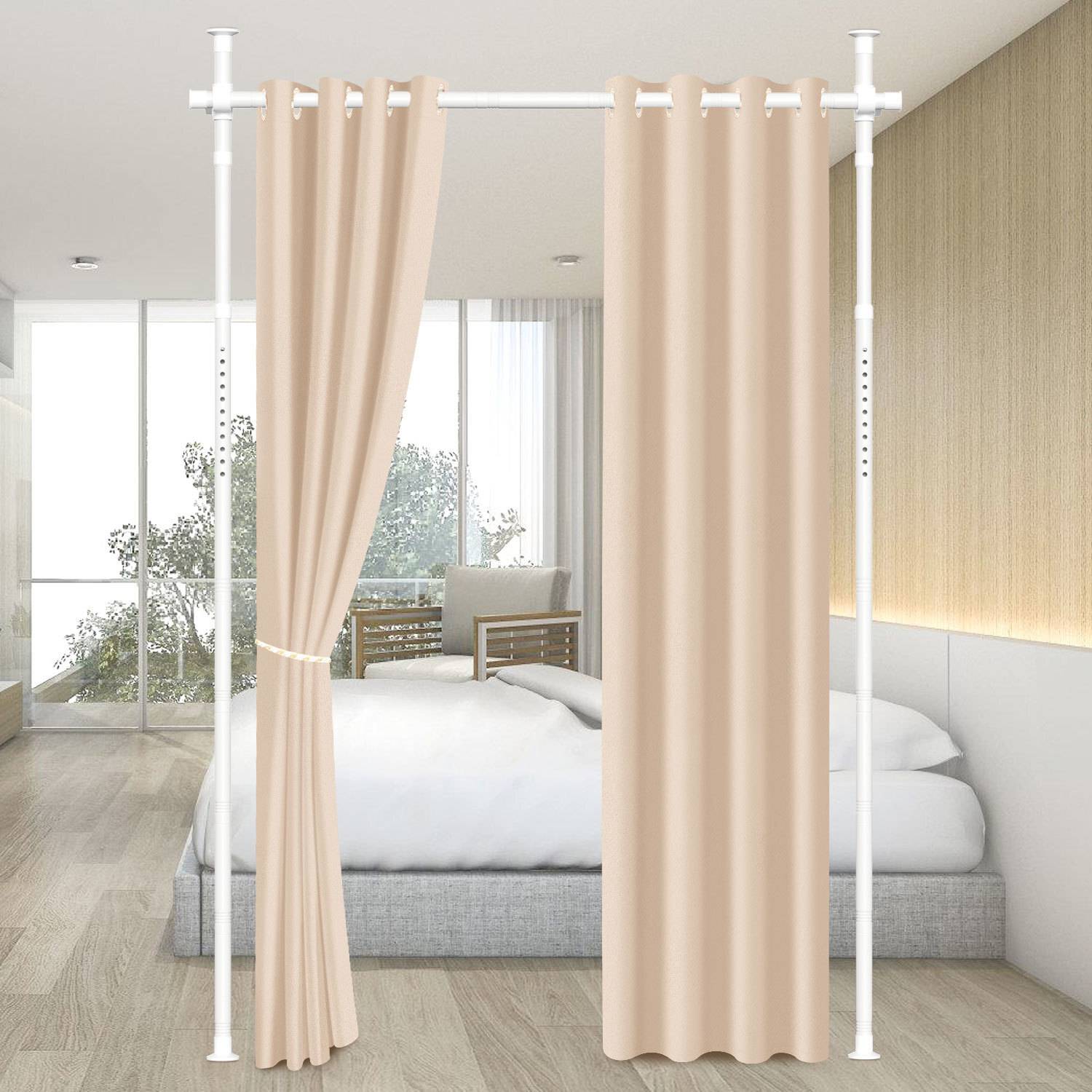 Ein beiger Vorhang verdeckt teilweise ein modernes Schlafzimmer mit einem Bett, hellem Holzboden und einem Stuhl in der Nähe eines Fensters.