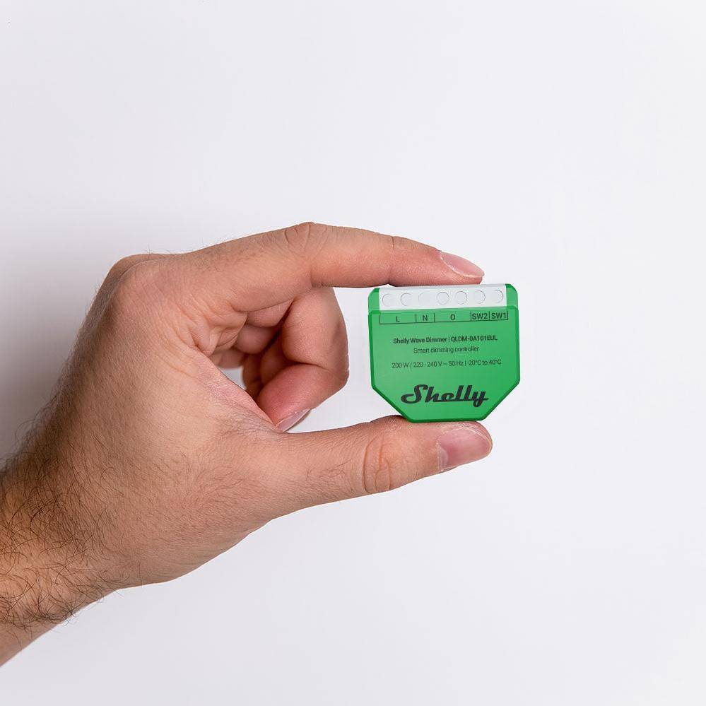 Eine Hand, die ein kleines grünes elektronisches Gerät mit der Aufschrift 