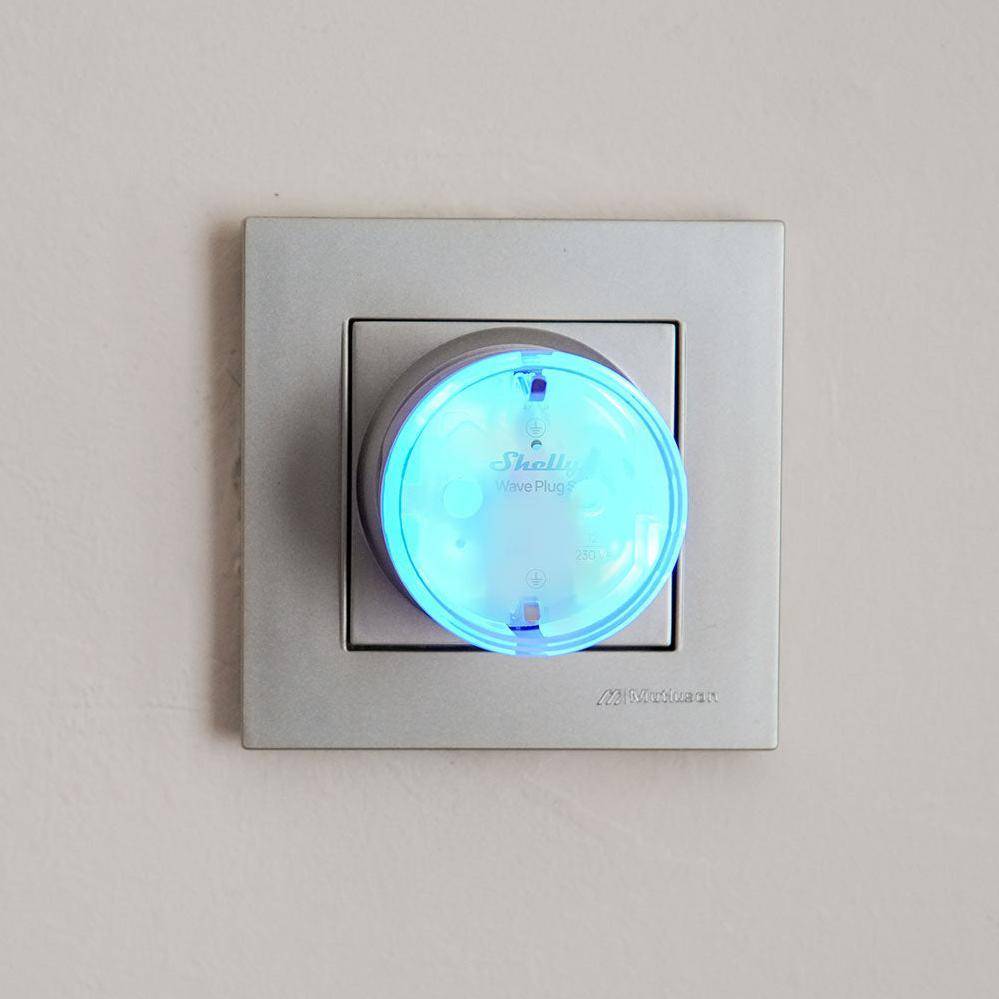 Ein silberner Wandschalter mit einem runden, blauen leuchtenden Smart-Stecker, der mit 