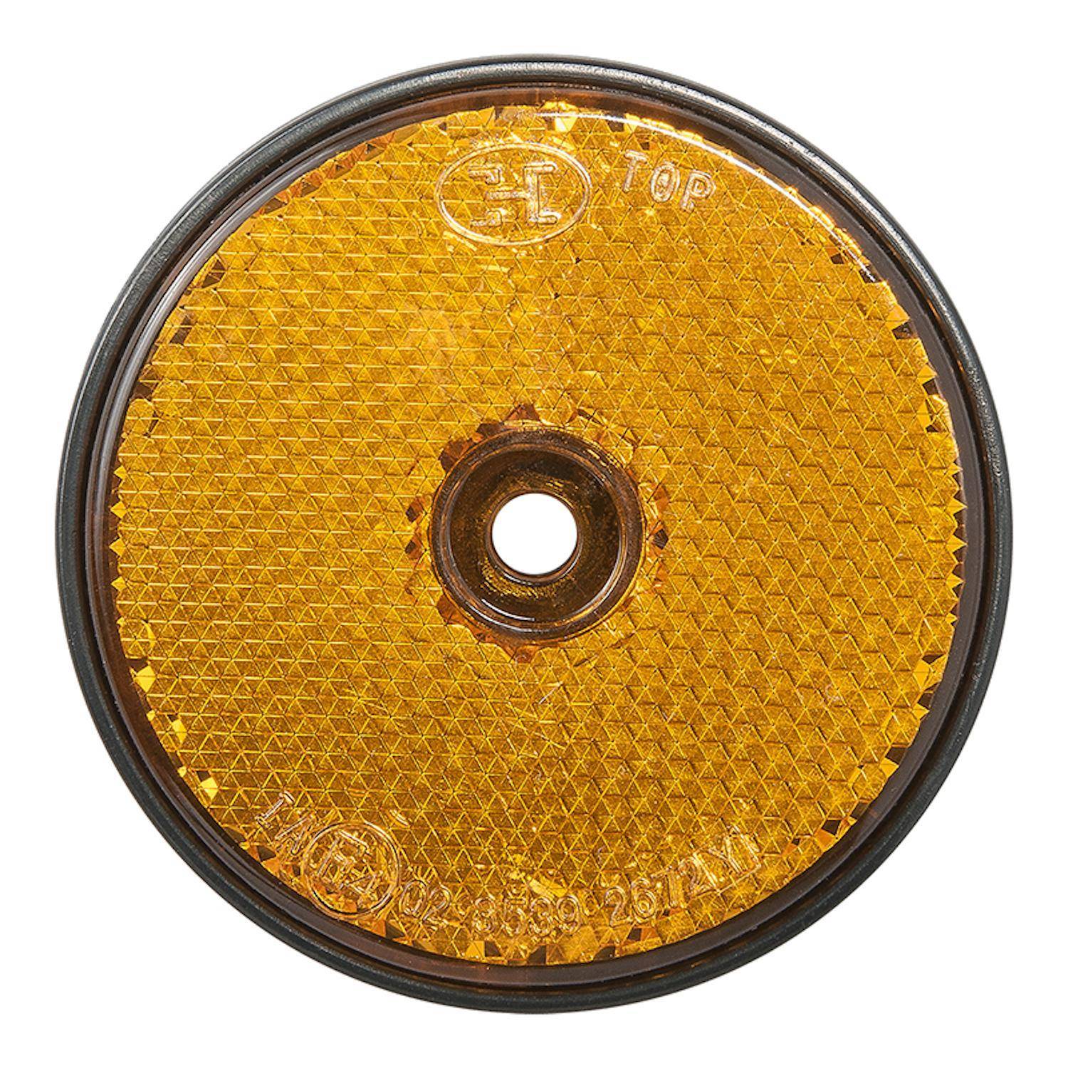 Ein runder, bernsteinfarbener Fahrradrückstrahler mit einer strukturierten Oberfläche und einem zentralen Loch, der zur Sichtbarkeit und Sicherheit verwendet wird.