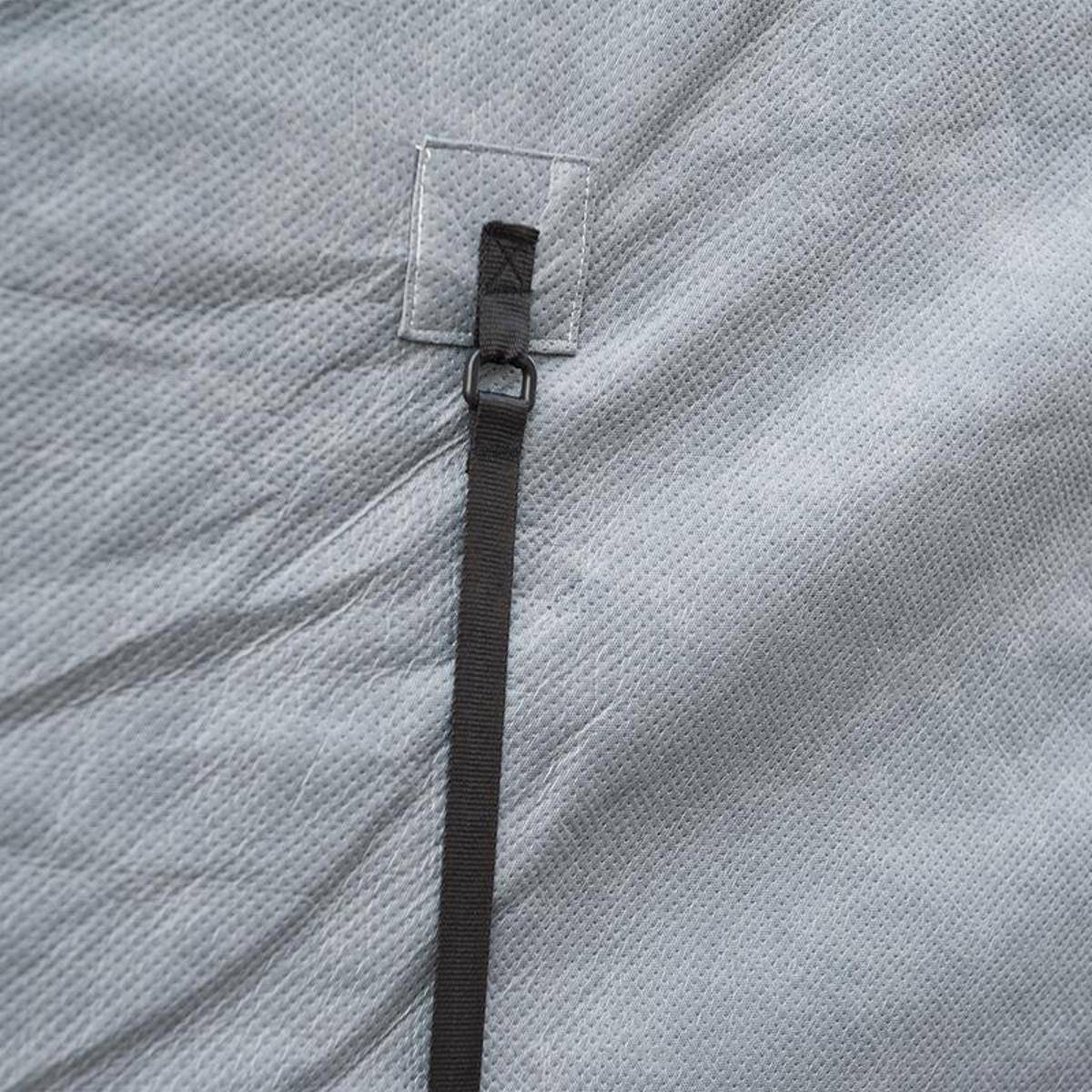 Eine Nahaufnahme eines grauen Stoffeinbands mit einem schwarzen Riemen, der an einer quadratischen Nahtversteifung befestigt ist.