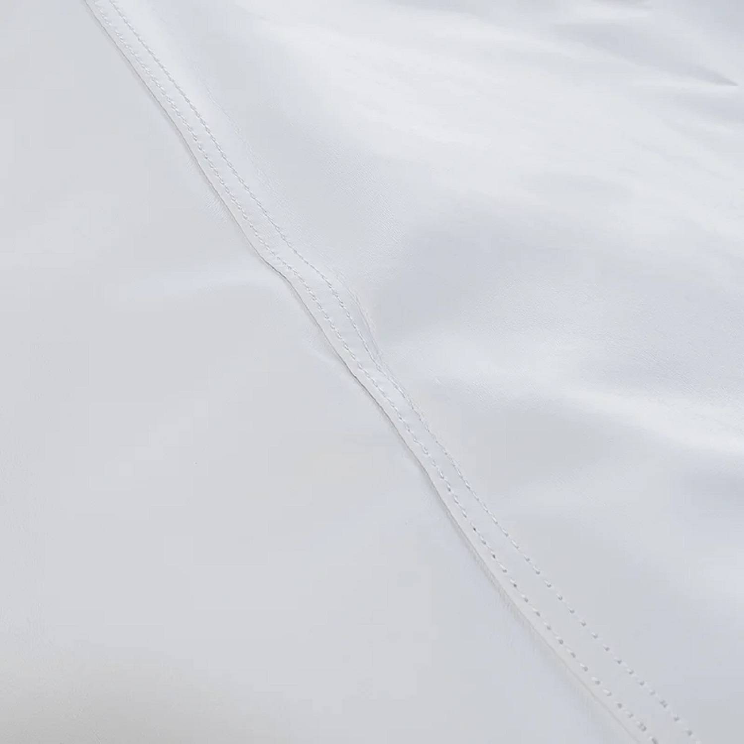 Eine Nahaufnahme einer glatten, weißen Satinoberfläche, die ihre glänzende Textur und subtile Lichtreflexion zeigt.