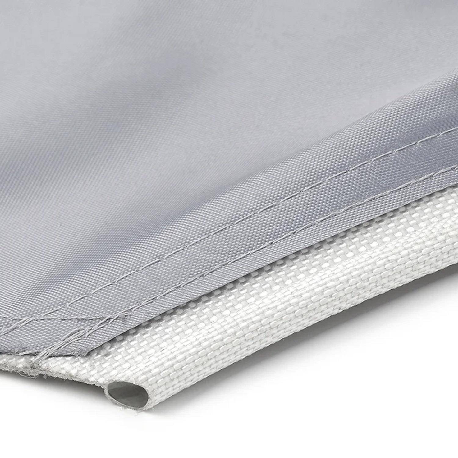 Eine Nahaufnahme eines gefalteten, hellgrauen Stoffes mit sichtbaren Nähten und einer weichen Textur, die die glatte Oberfläche und Saumdetails des Gewebes zeigt.