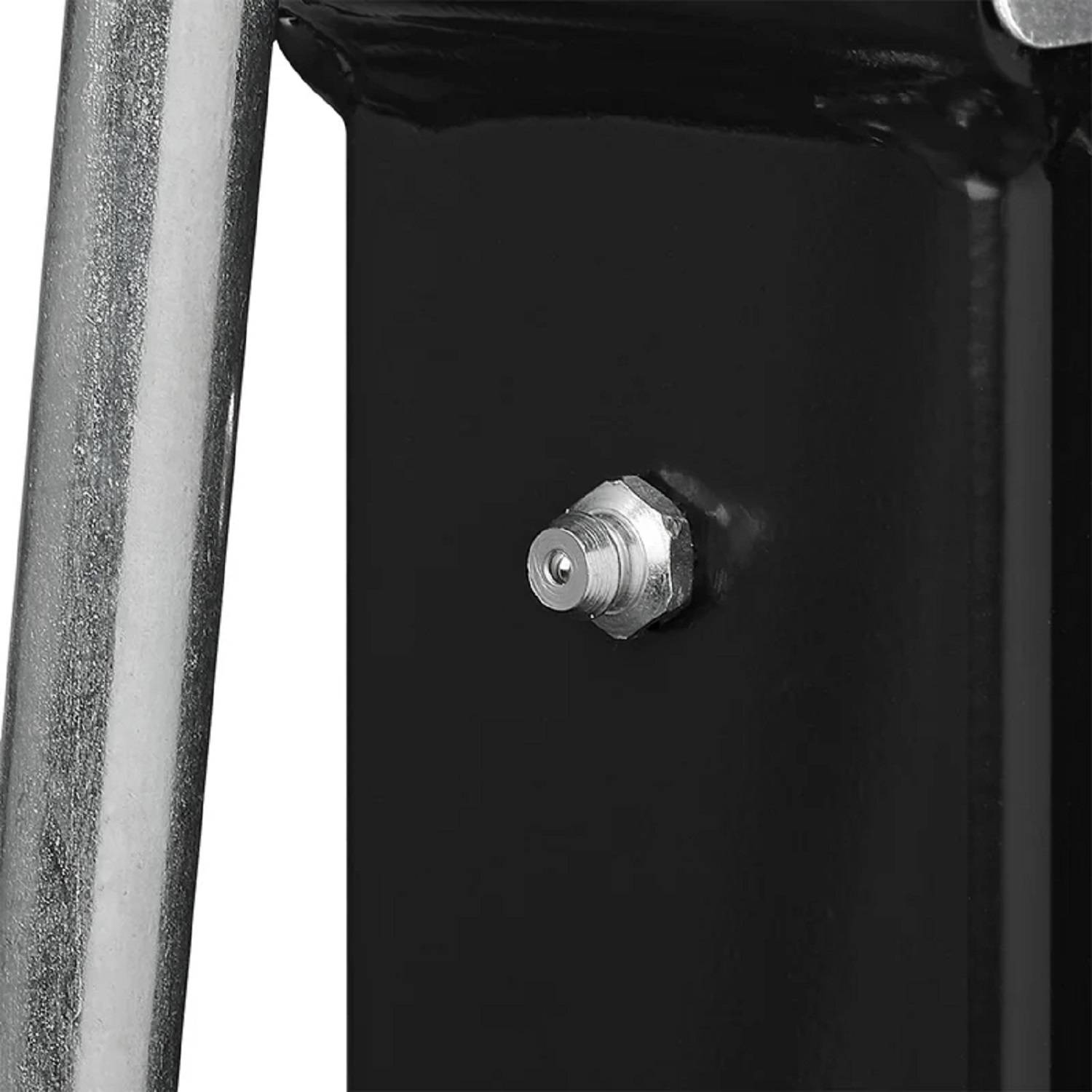 Ein Metallstück mit einem Bolzen, der an einer schwarzen Oberfläche befestigt ist, vermutlich Teil einer Maschine oder Ausrüstung.