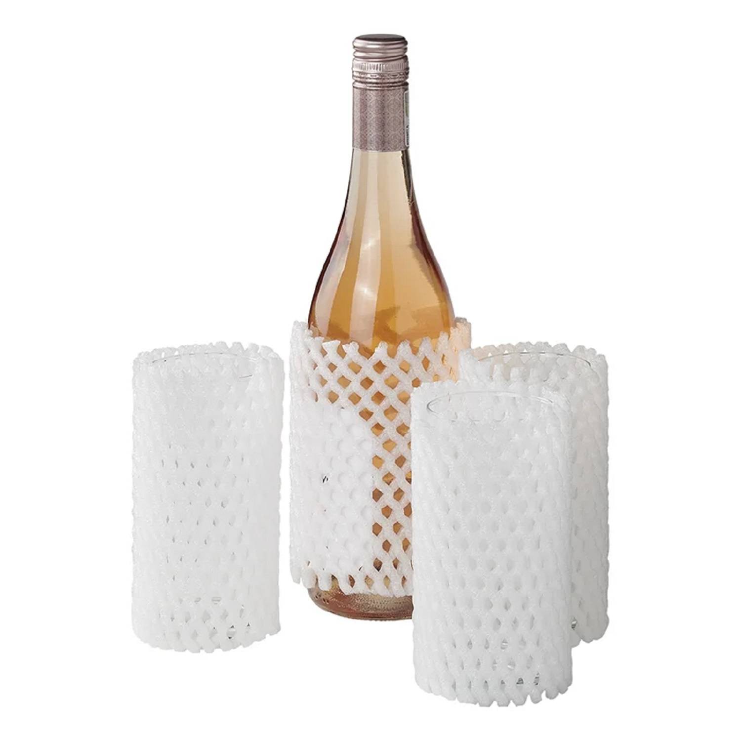 Eine Flasche und drei Gläser, in weiße Schutznetze eingewickelt, die auf einer Oberfläche stehen. Die Flasche ist mit einer hellfarbenen Flüssigkeit gefüllt.