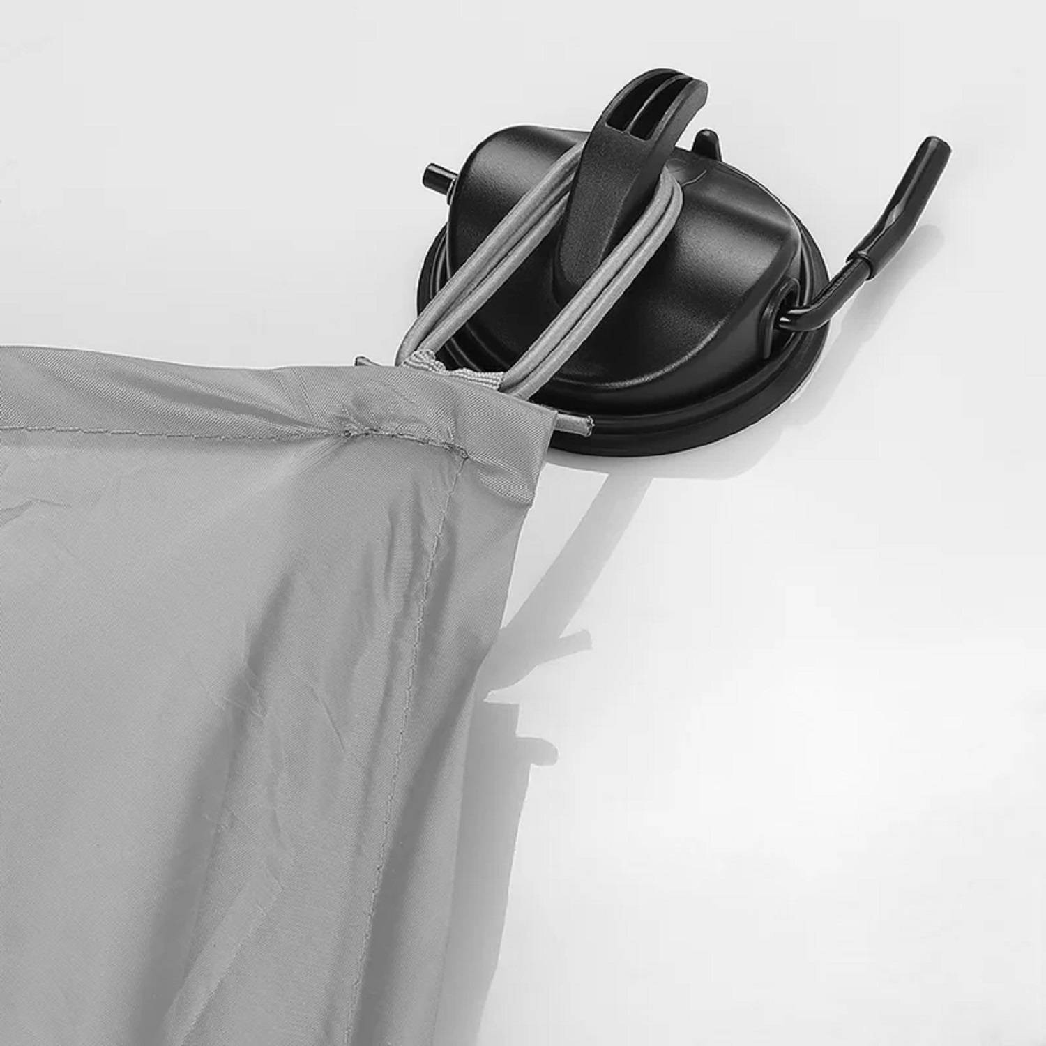 Graue Zeltpavillon-Ecke mit einem Saugnapf und Spanngurten auf einer weißen Oberfläche gesichert, was eine stabile Outdoor-Aufstellung andeutet.