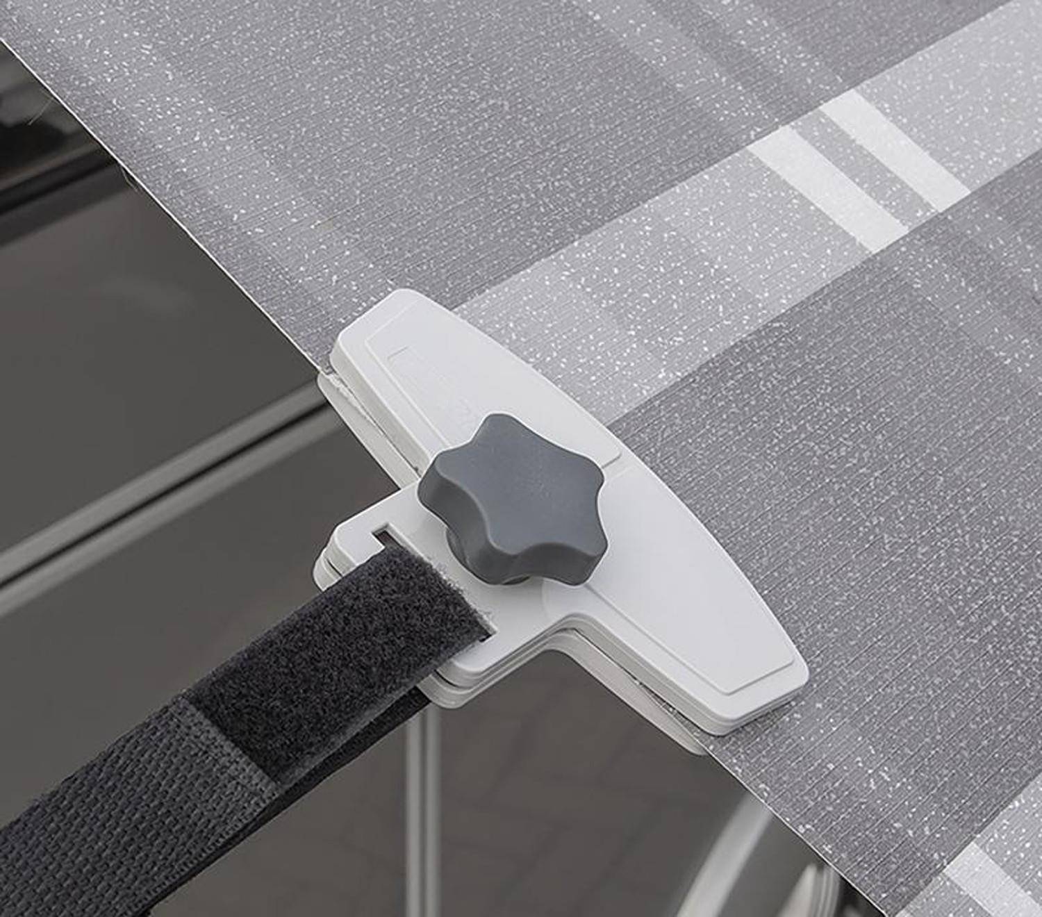 Ein grau-weißer Regenschirm verfügt über eine Befestigungsklammer, die an seinem Rand angebracht ist und seine sichere Befestigung an einer Oberfläche demonstriert.