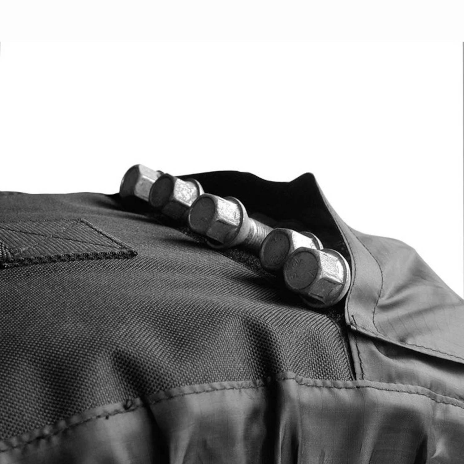 Eine Reihe glänzender Metallstimmwirbel auf einem schwarzen Gitarrenheadstock, mit einer sichtbaren gesteppten Tasche im Stoffhintergrund.