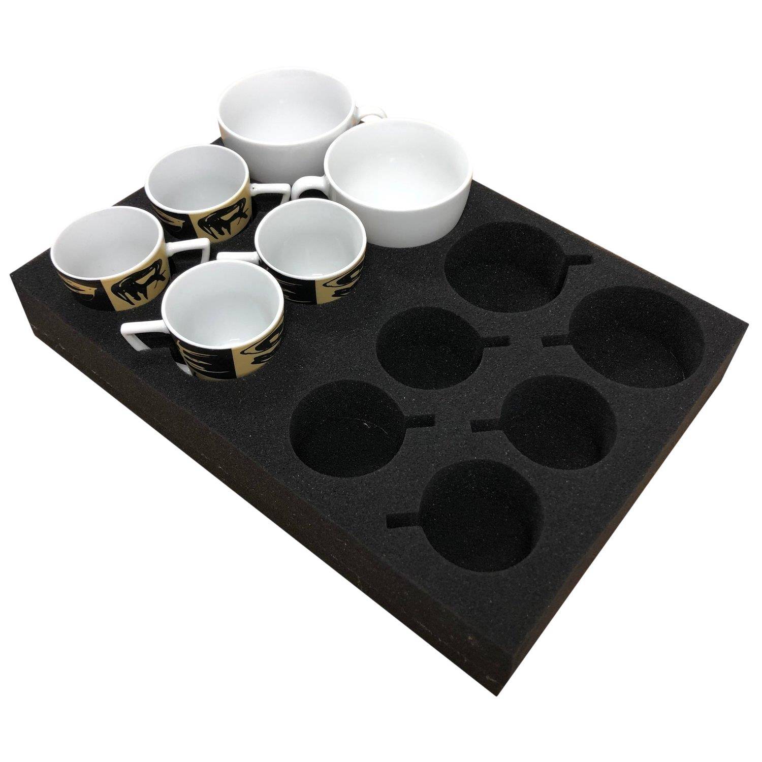 Ein Schaumstofftablett mit sechs weißen Bechern in ausgeschnittenen Fächern, daneben vier leere Fächer, die für zusätzliche Becher vorgesehen sind.