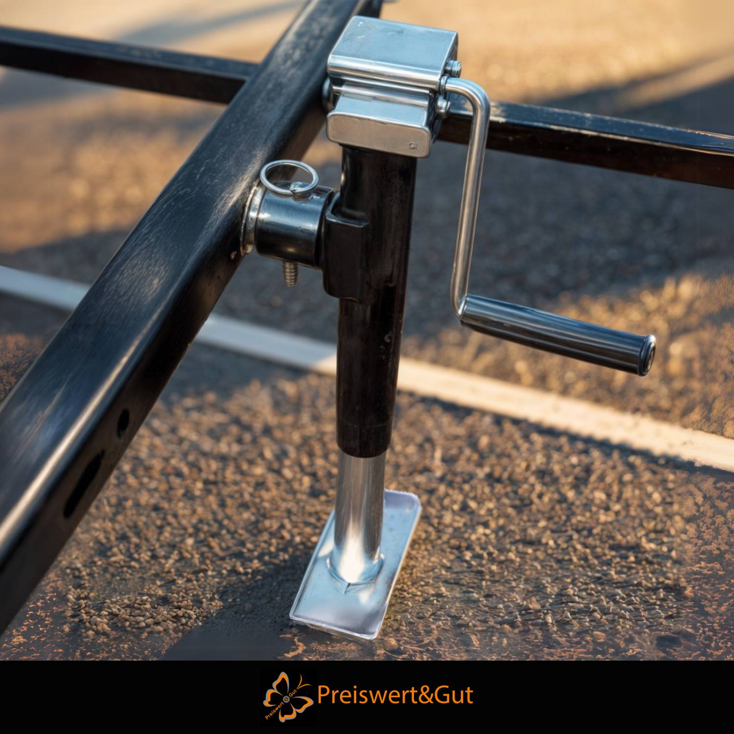 Ein Nahaufnahme eines Metallhebers mit Kurbel auf einem Pflaster, der seine mechanische Struktur zeigt. Unten steht der Text „Preiswert & Gut