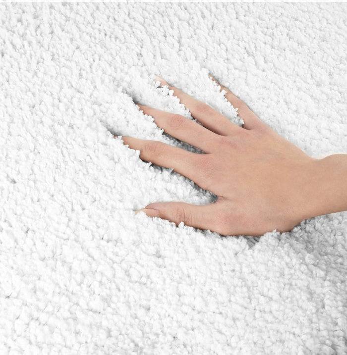 Eine Hand drückt auf weichen, weißen strukturierten Stoff und hinterlässt eine Abdruckform.