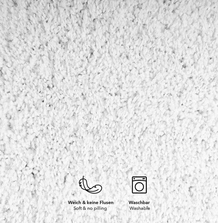 Weicher, weißer strukturierter Stoff mit Symbolen für 'keine Pillingbildung' und 'waschbar'.