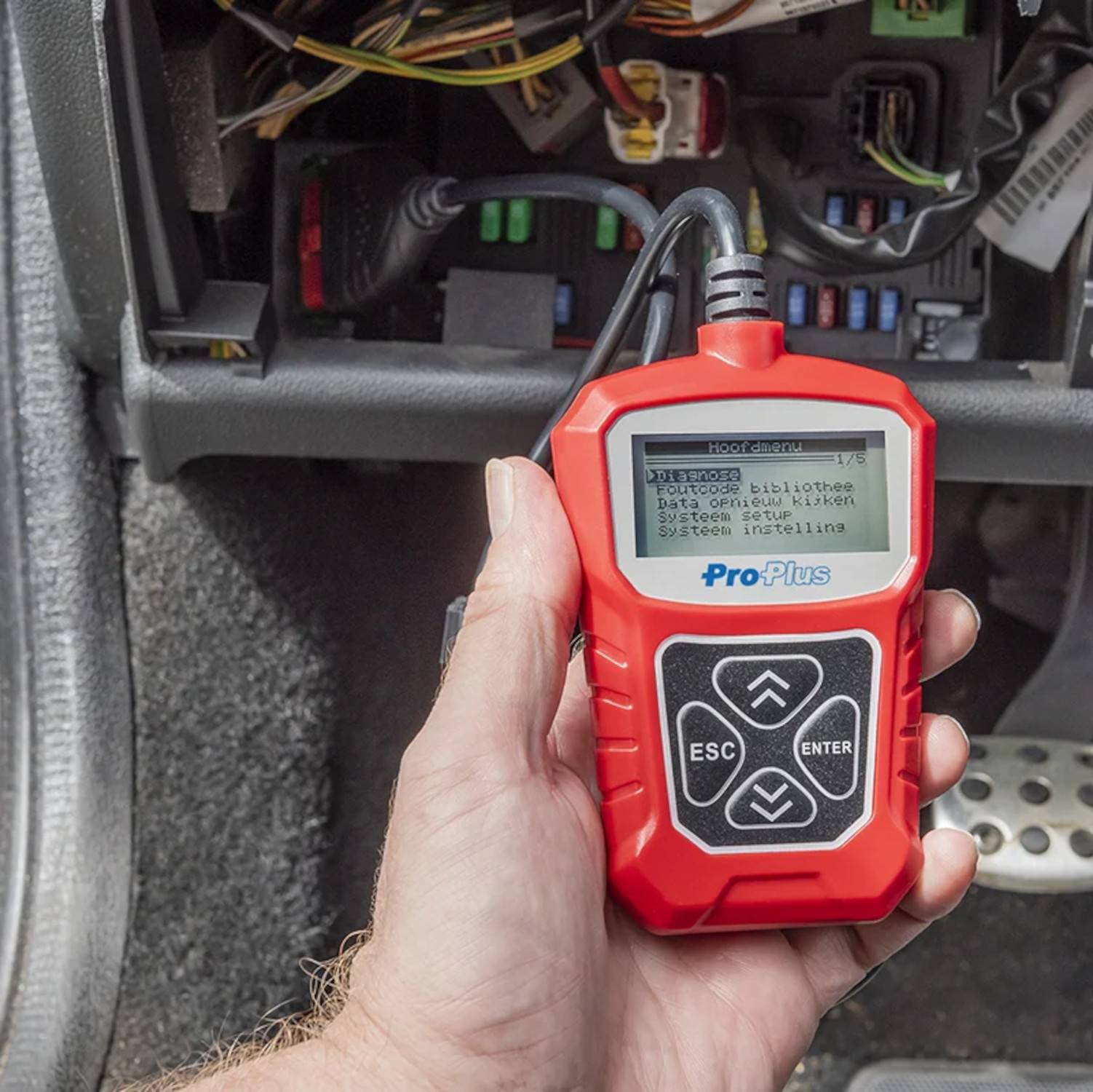 Eine Person hält ein rotes Diagnosegerät, das einen Fehlercode 