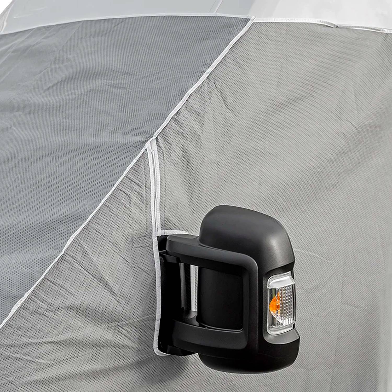 Eine Schutzabdeckung ist über den Seitenspiegel eines Fahrzeugs gehängt, der sie vor den Witterungseinflüssen schützt.