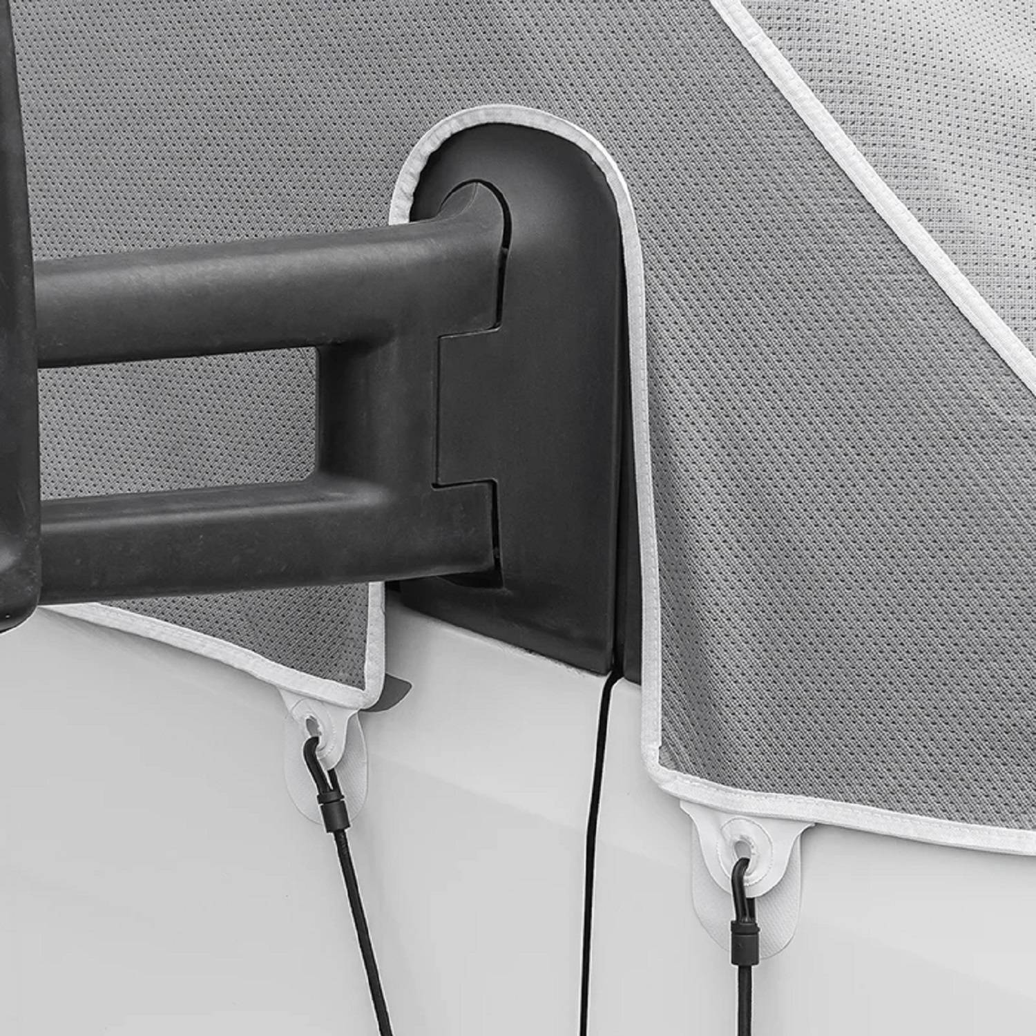 Ein Fahrradträger, der an der Rückseite eines Fahrzeugs angebracht ist, teilweise mit einem Schutzüberzug in Grau und Weiß bedeckt, mit Befestigungen gesichert.