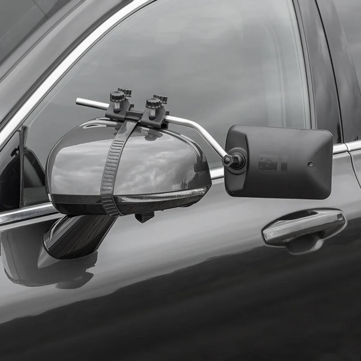 Ein Außenspiegel eines Autos mit einem zusätzlichen Anhängespiegel, der nach außen herausragt und eine breitere Rückansicht beim Ziehen eines Anhängers ermöglicht.