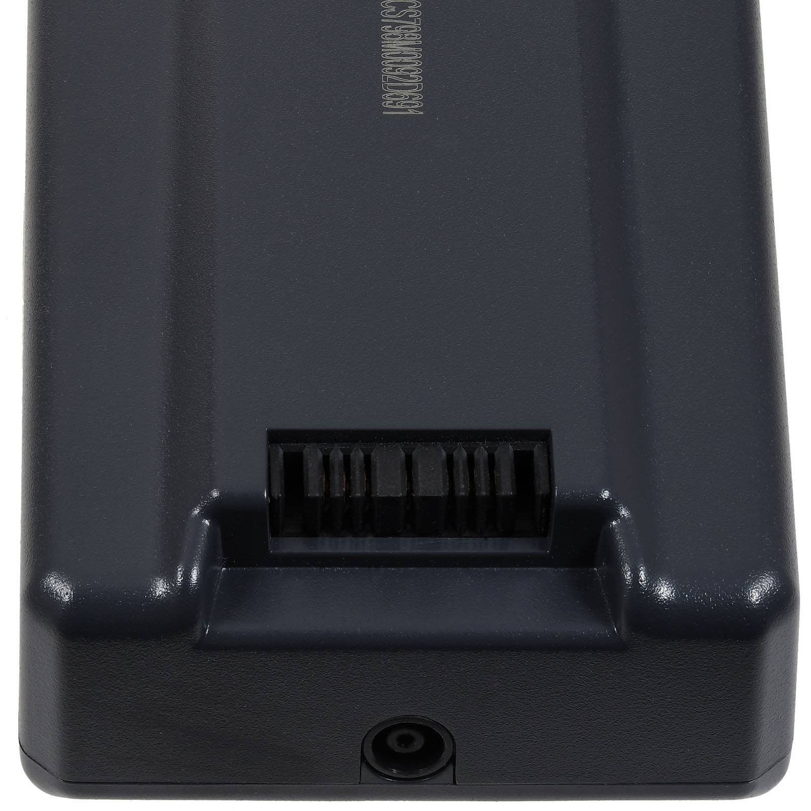 Ein schwarzes rechteckiges elektronisches Gerät mit einem Schlitz und Anschluss oben, möglicherweise für ein Netzkabel, von einem Winkel aus betrachtet.