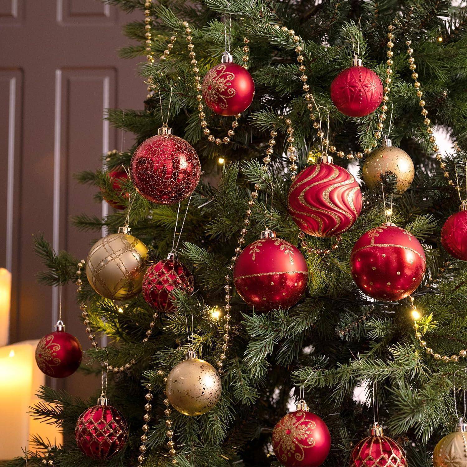 Ein Weihnachtsbaum, geschmückt mit roten und goldenen Kugeln und Perlen, mit weichem Kerzenlicht im Hintergrund, das eine festliche Atmosphäre schafft.
