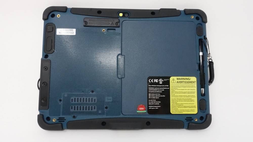 Das Bild zeigt die Rückseite eines robusten elektronischen Geräts mit einem Warnhinweis, Zertifizierungsmarkierungen und einem Kompartimentbereich.